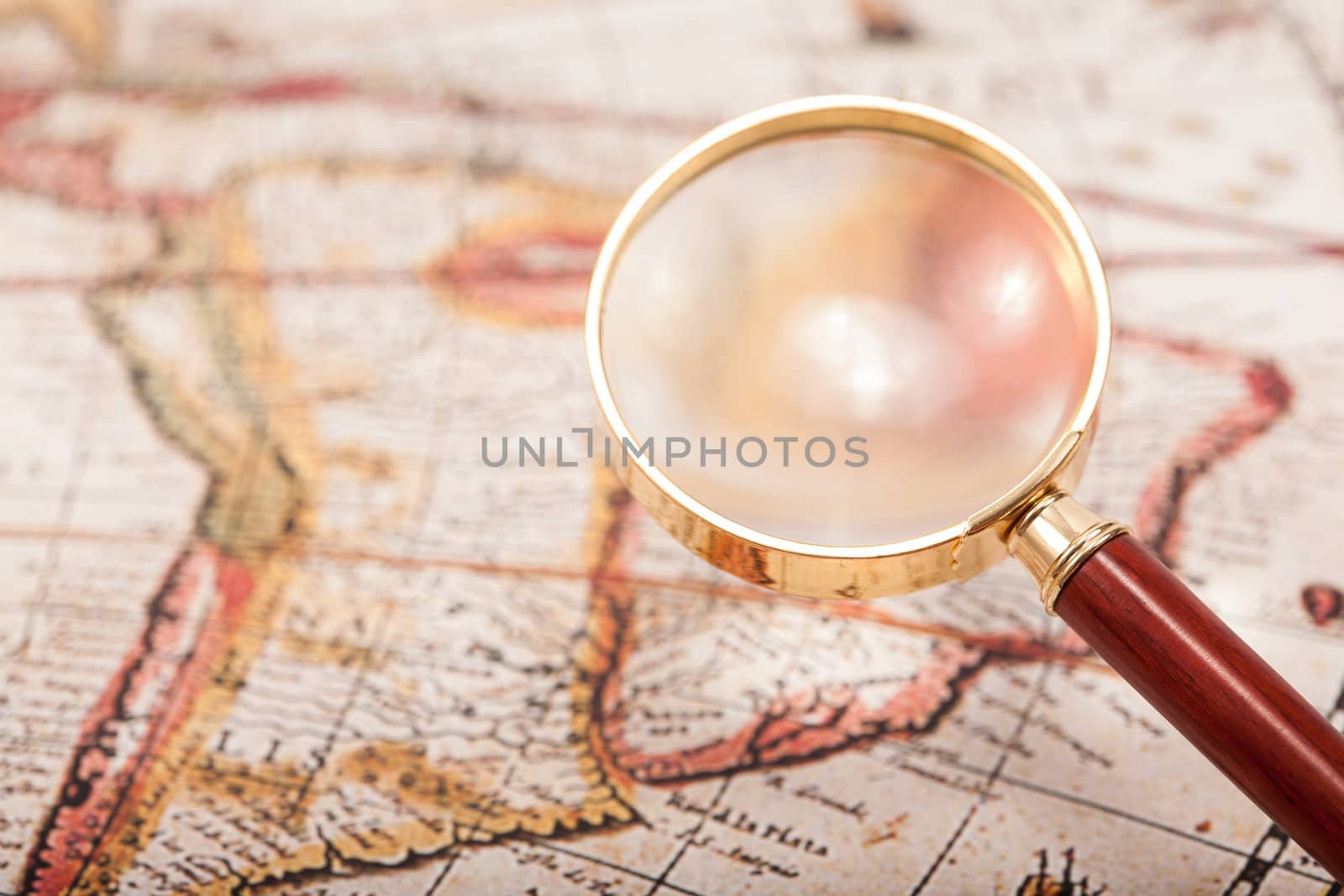 A beautiful antique map with an old magnifying glass with golden details.