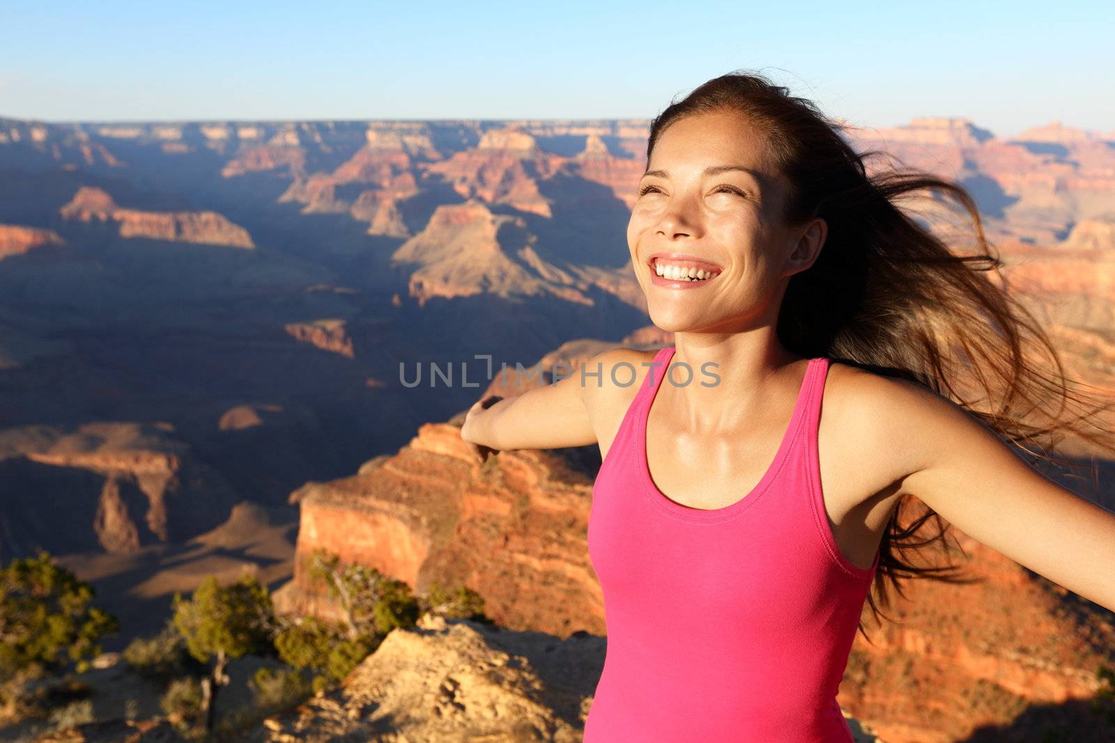 Happy freedom woman tourist in Grand Canyon smiling free in happiness during summer travel trip in Grand Canyon, South Rim, Arizona, USA.
