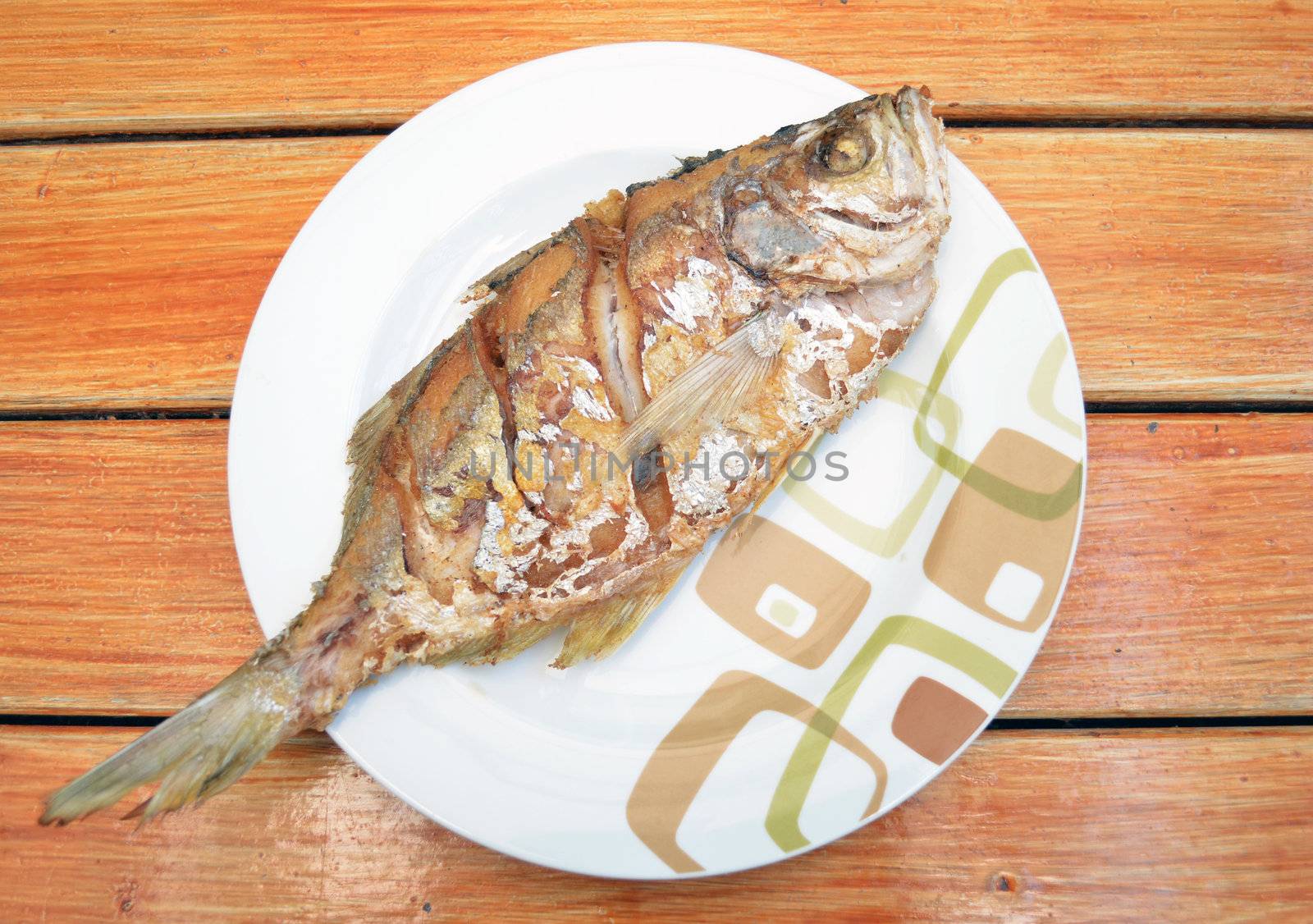 Fried fish on dish by siraanamwong