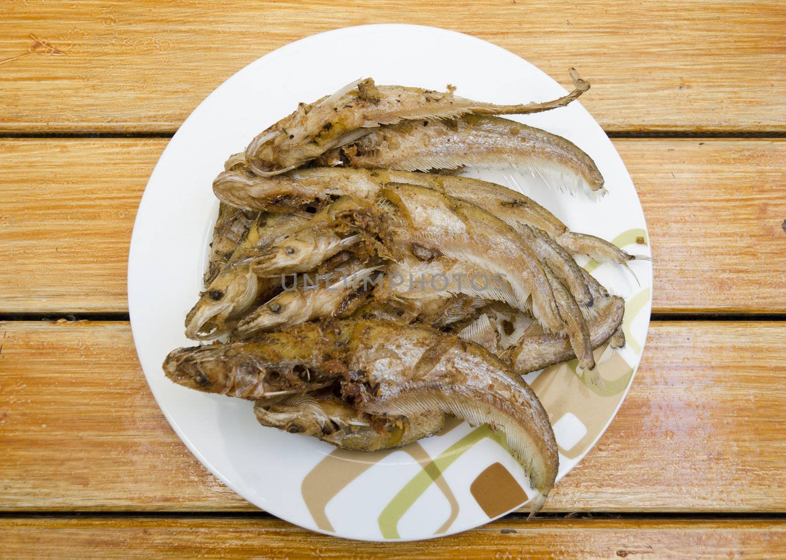 Fried fishes on dish by siraanamwong