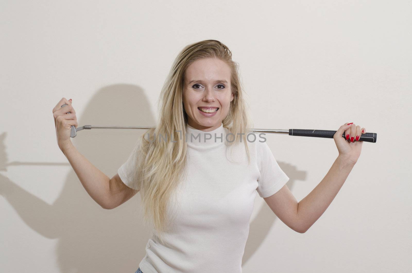 blonde girl holding golf club on her shoulders smiling