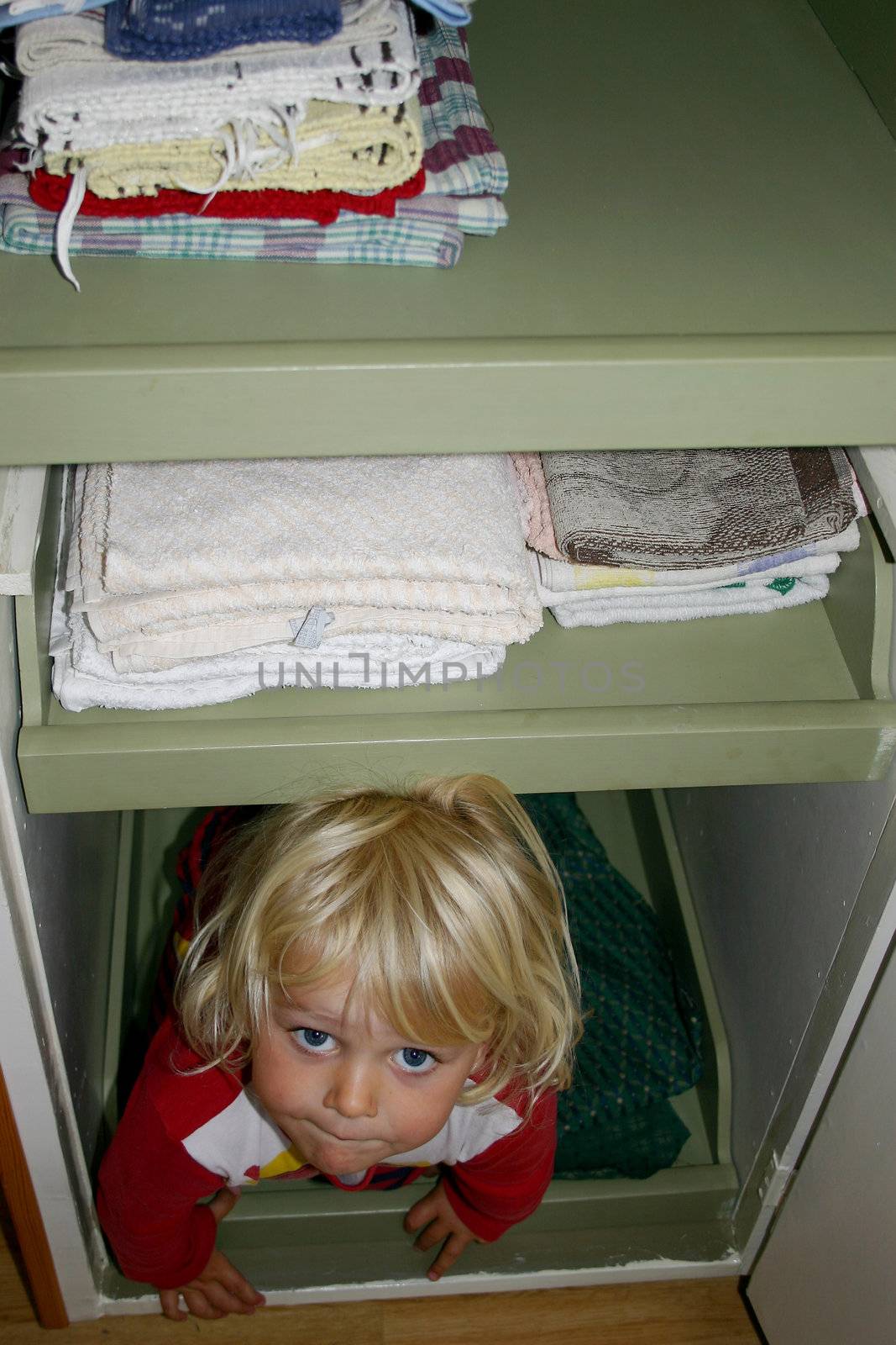Child hiding in the linnen cabinet by annems