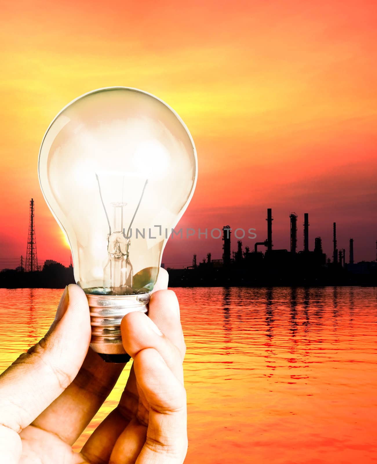 Hand hold the light bulb with oil refinerySave power concept