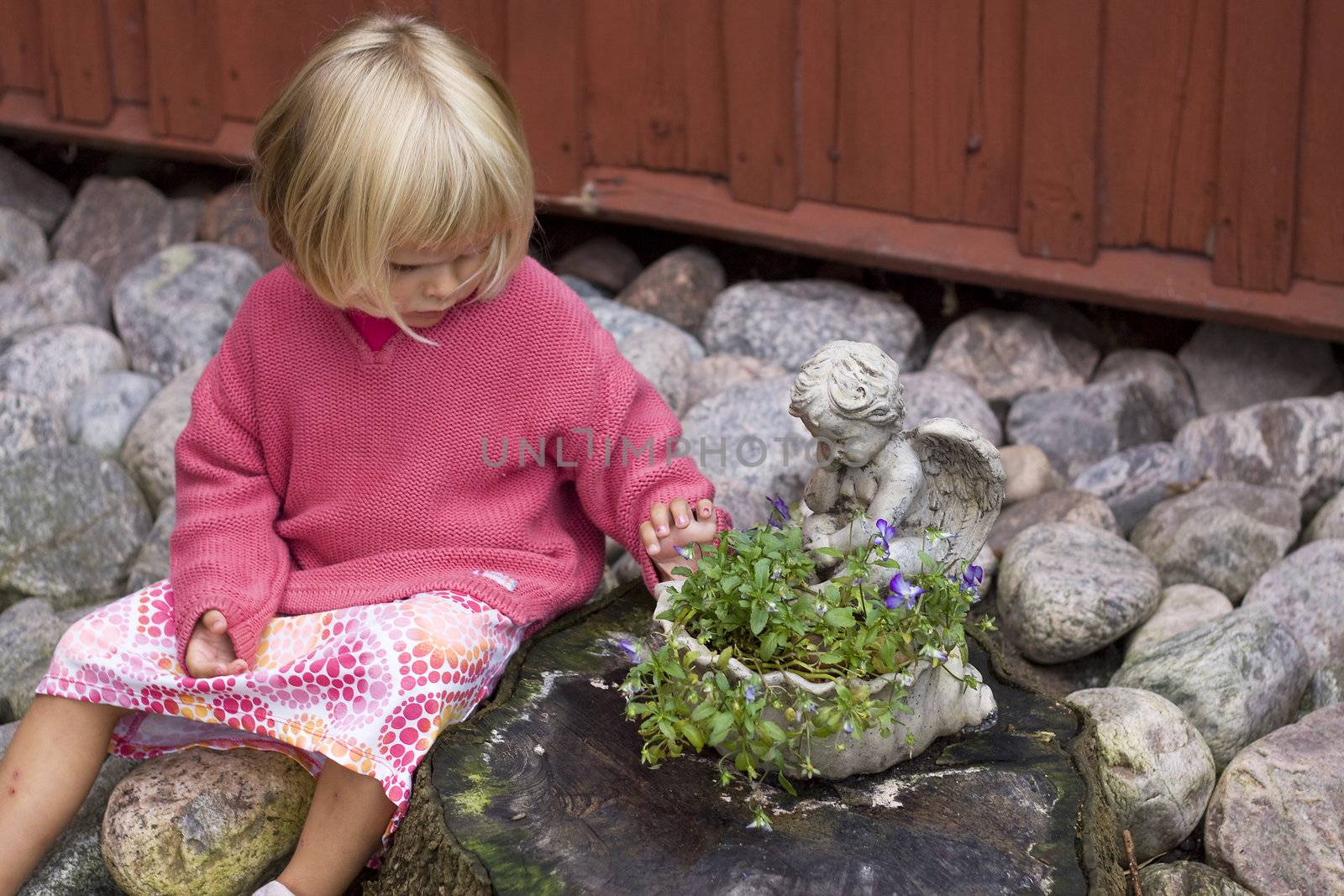 Girl sitting next to flower pot
