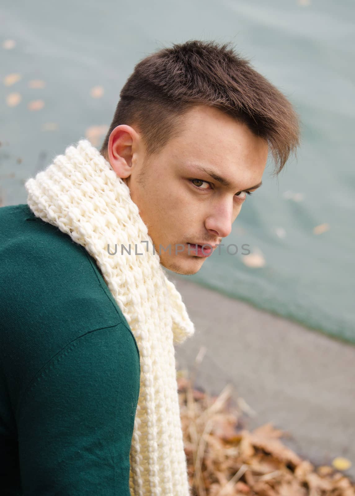 Attractive young man with scarf outdoors in nature (river, lake)