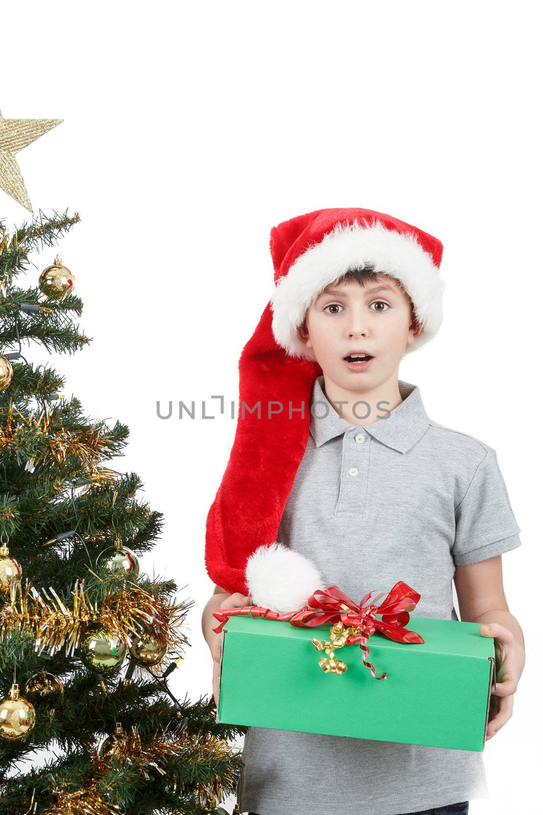 surprised boy in santa hat with christmas present on white background