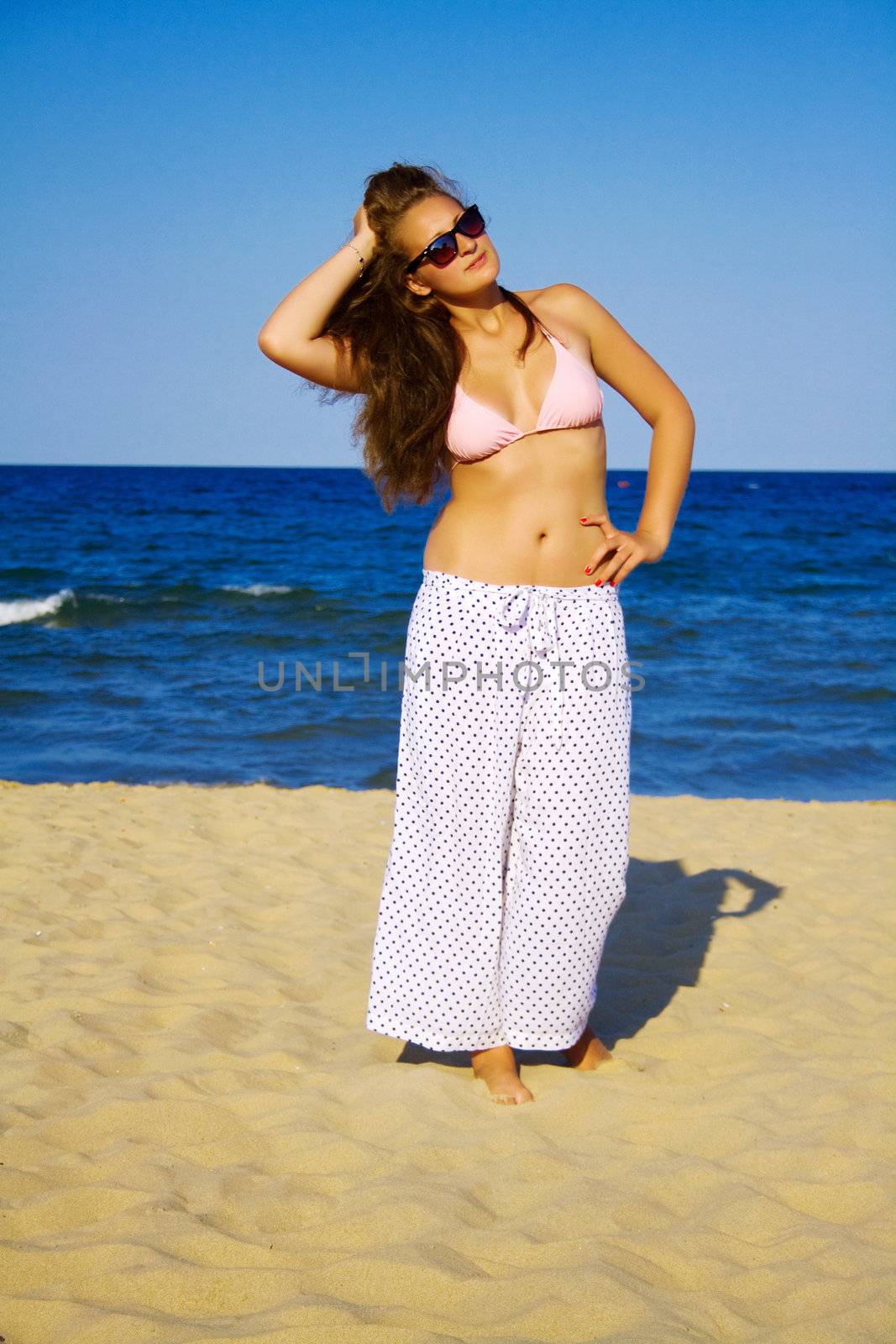 Portrait of a beautiful woman in glasses on the beach