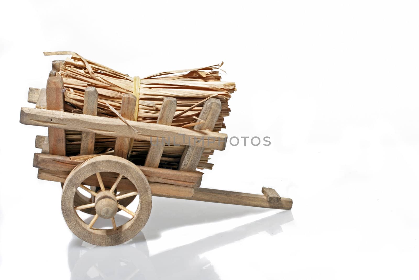 Old handcart with straw on a white background