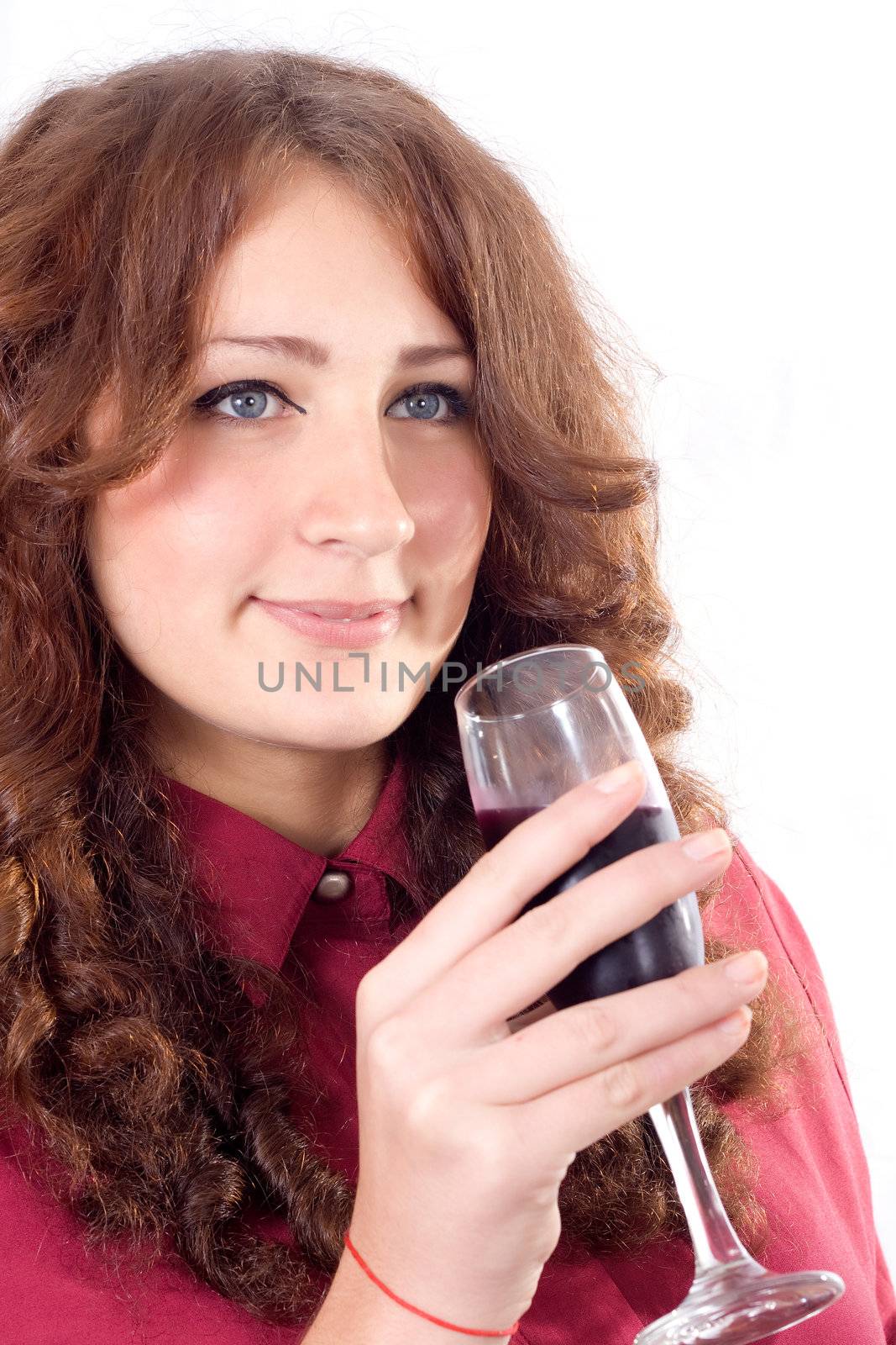 Closeup of beautiful female lips drinking wine from a glass with dewdrops on it.
