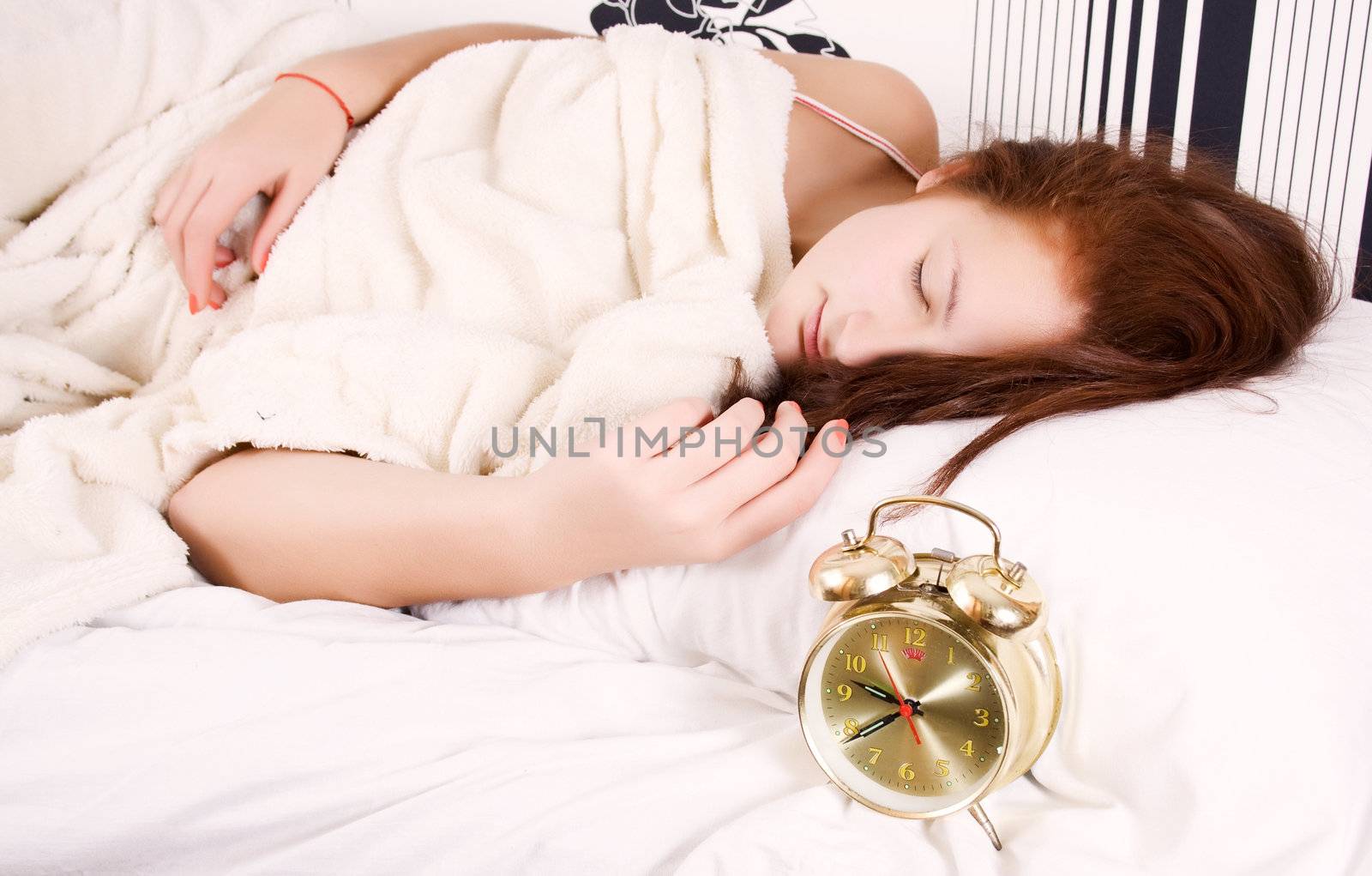 The girl sleeps on bed-clothes.
