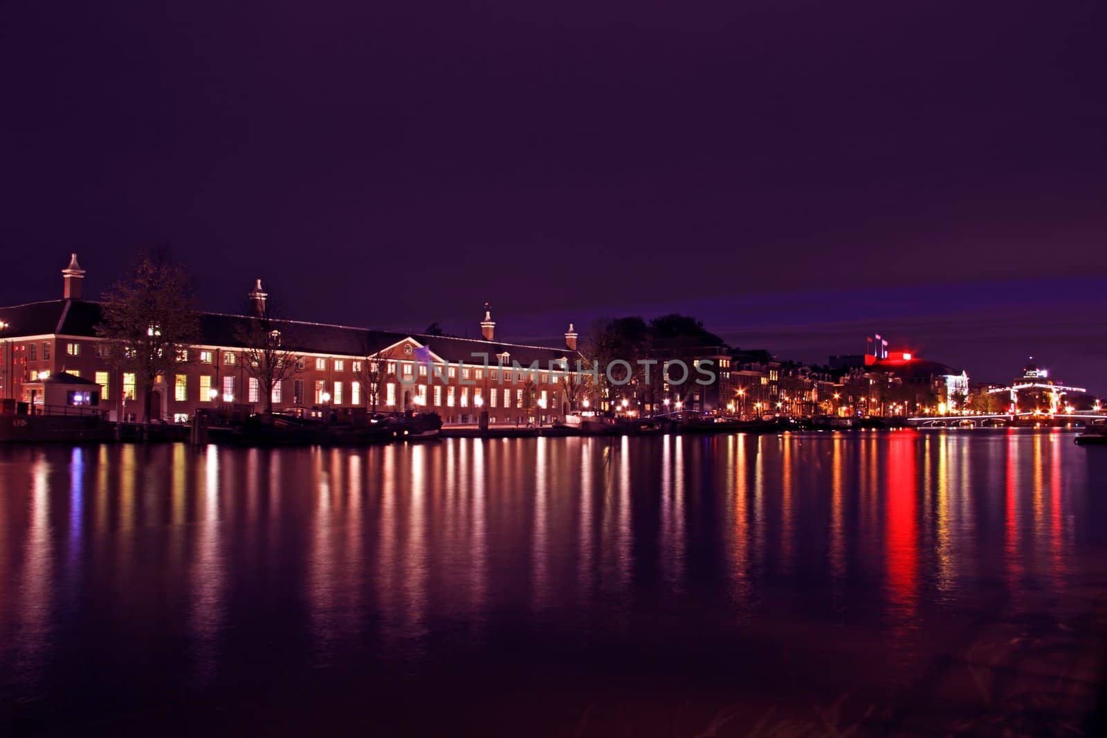 City scenic from Amsterdam at the river Amstel with the Thiny bridge in the Netherlands at night
