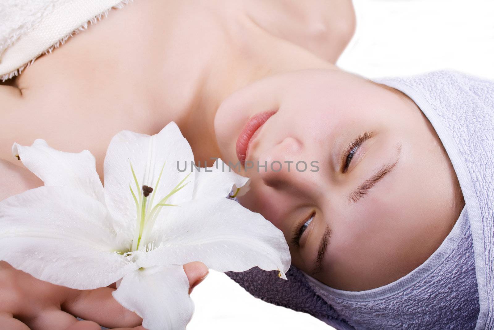 Portrait of beautiful young woman with health skin and with flower on her shoulder