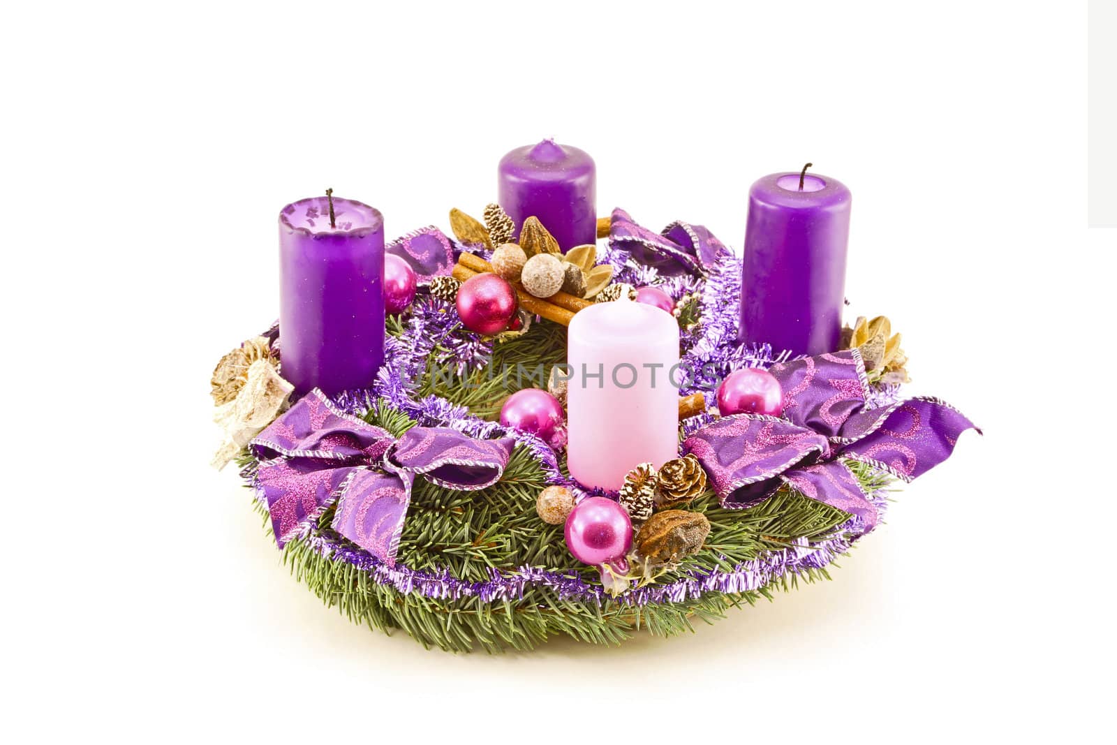 Advent wreath decorated with purple candles and christmas ornaments