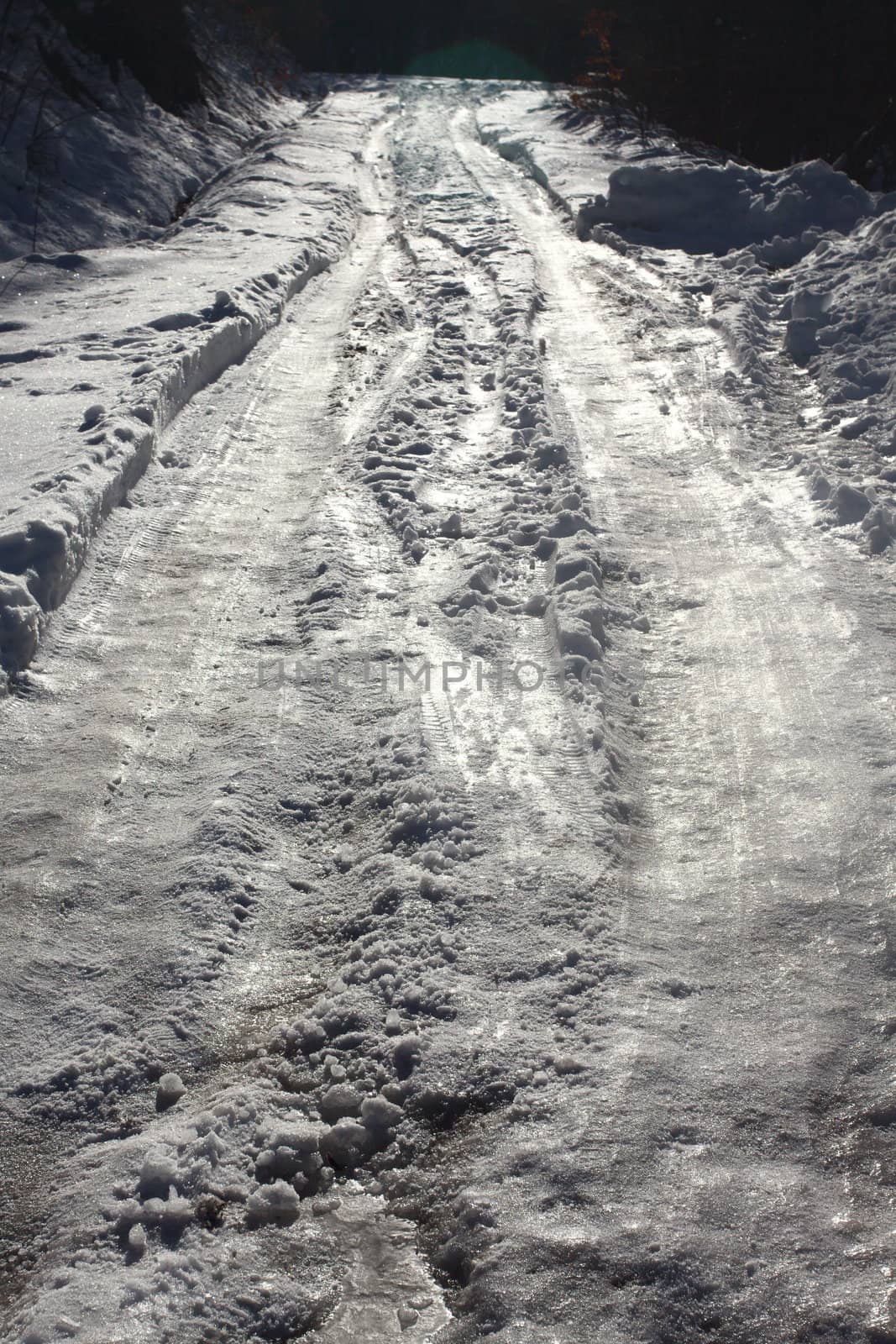 very frozen mountain road, lit by sunlight