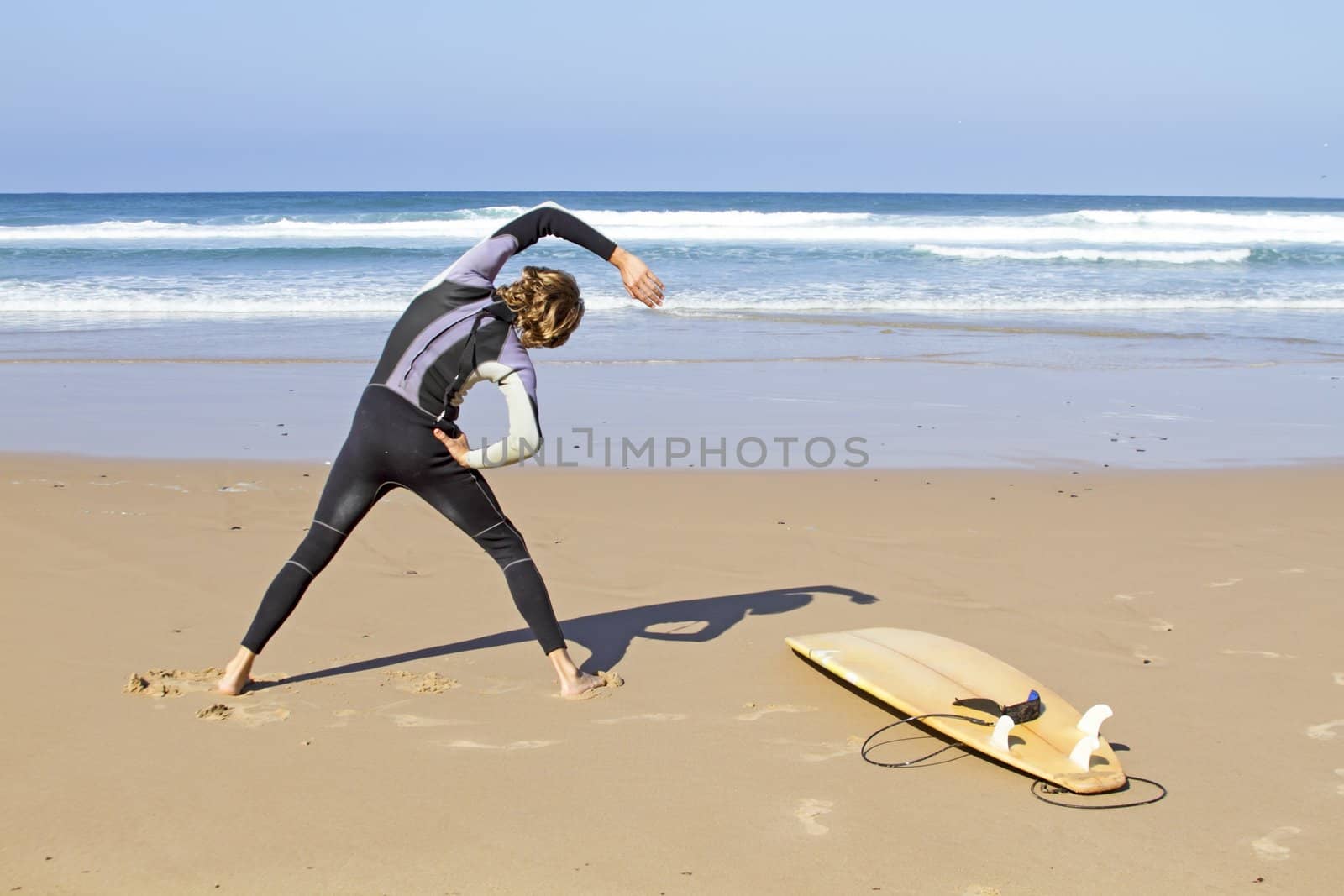 Young guy doing exercises before going to surf