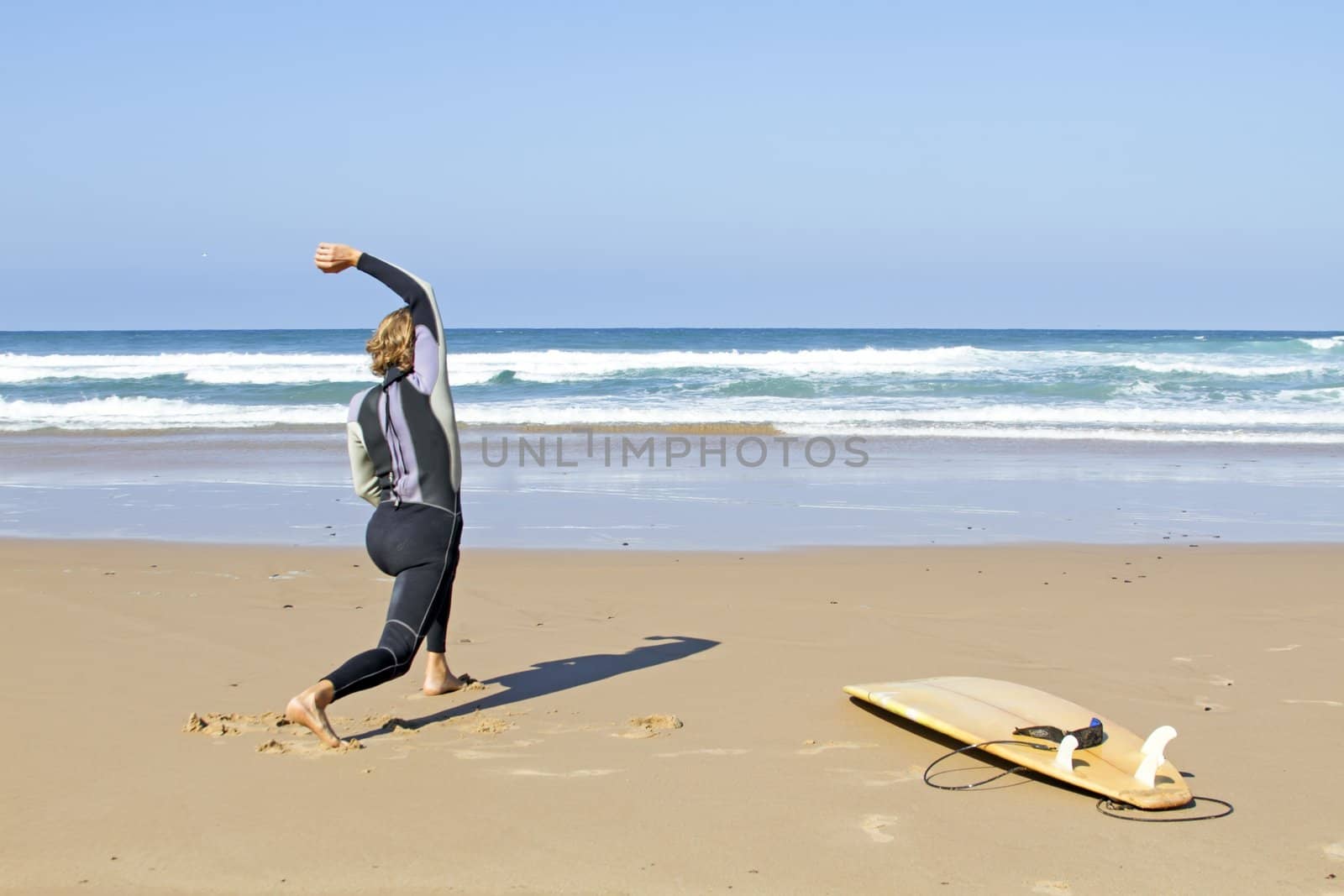 Young guy doing exercises before going to surf