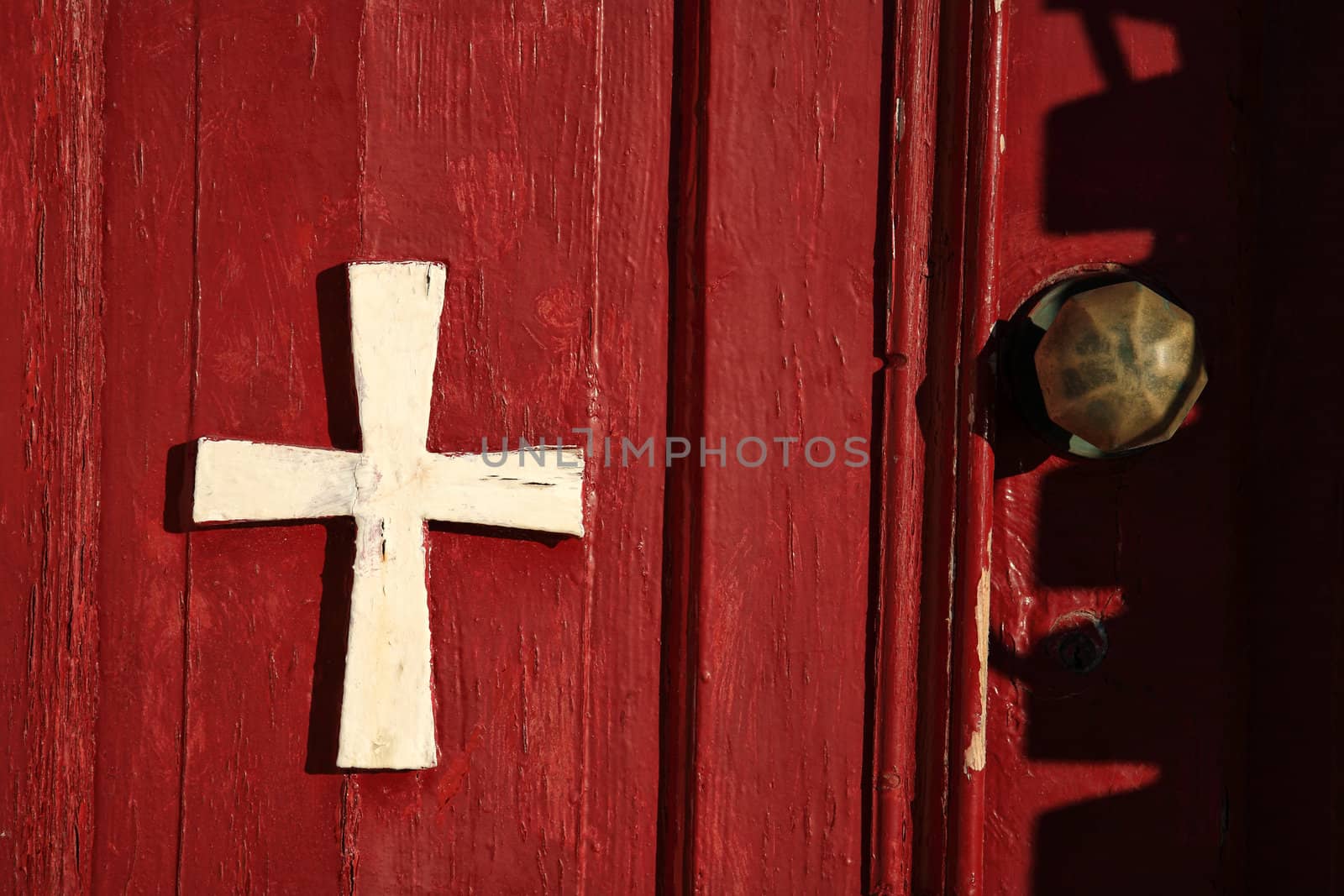 cross on a red wooden door closeup