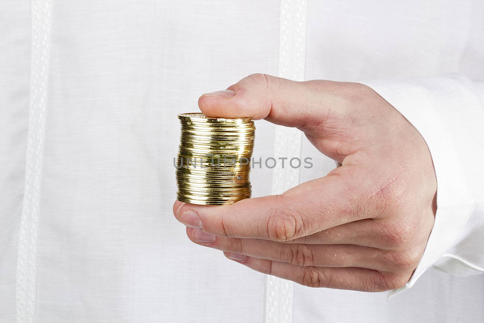 Close-up photograph of a man's hand holding a stack of coins.