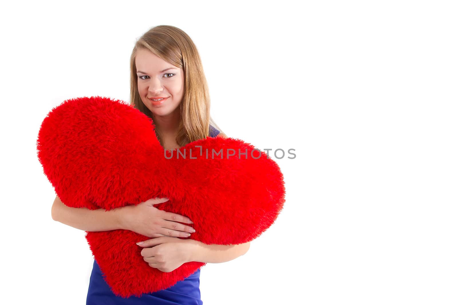 Young beautiful  girl  hugs a big soft heart. Feast of St. Valentine's Day.