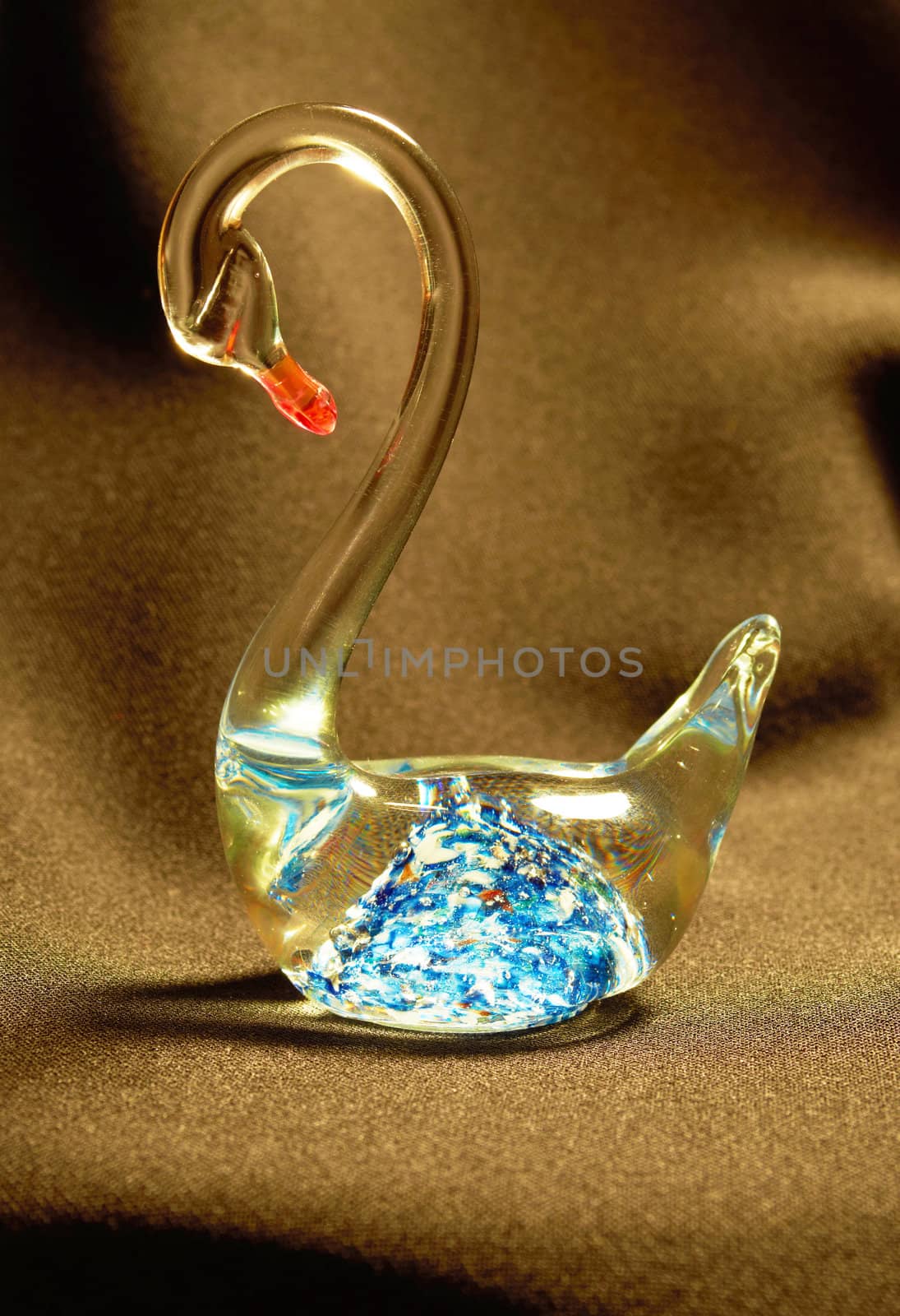 Figurine glass swan with a bright blue pattern on a black background