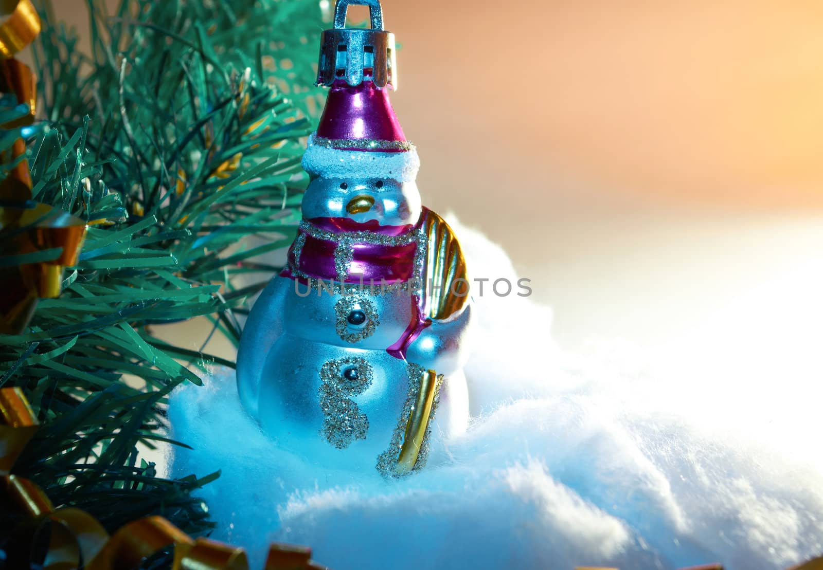 Glass Christmas toy  in the form of snowman on the artificial Christmas tree branches 