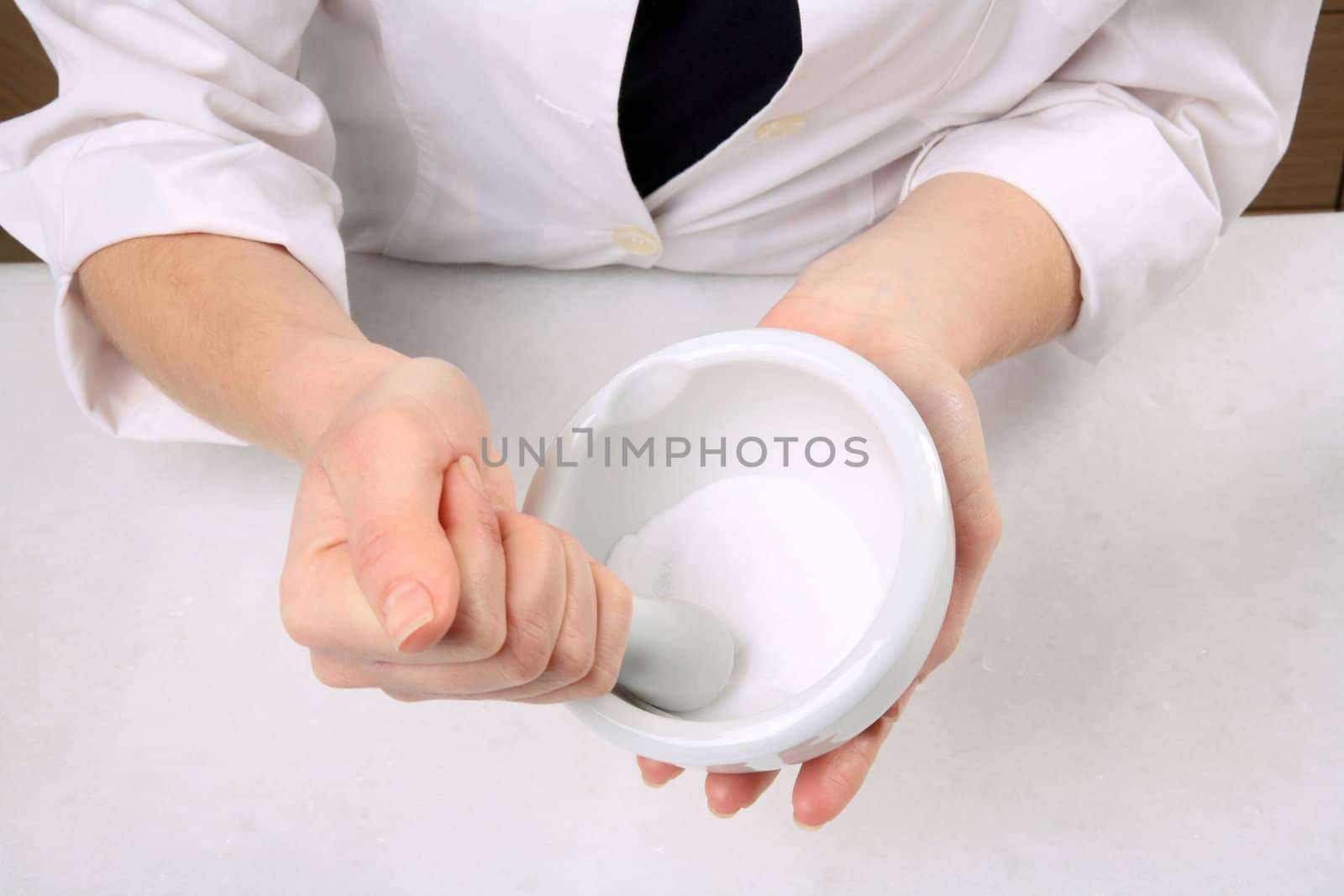 hands crushing on mortar with pestle