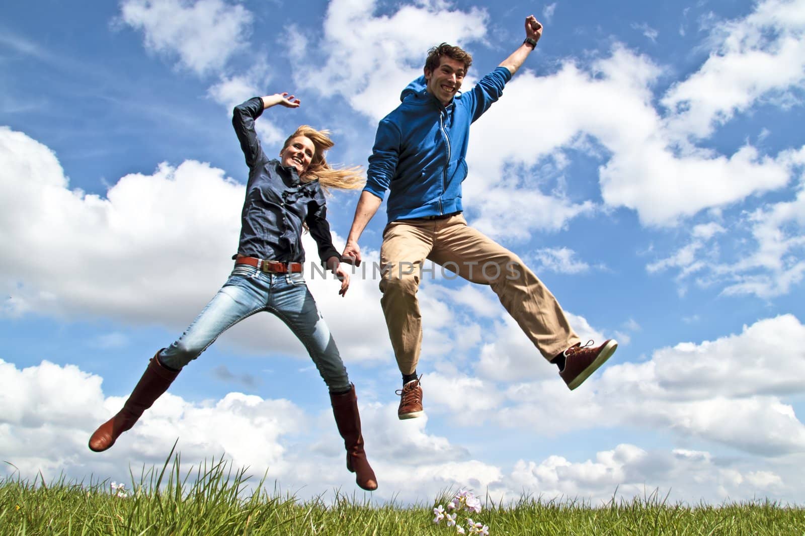 Young enthousiastic couple jumping up in the air by devy