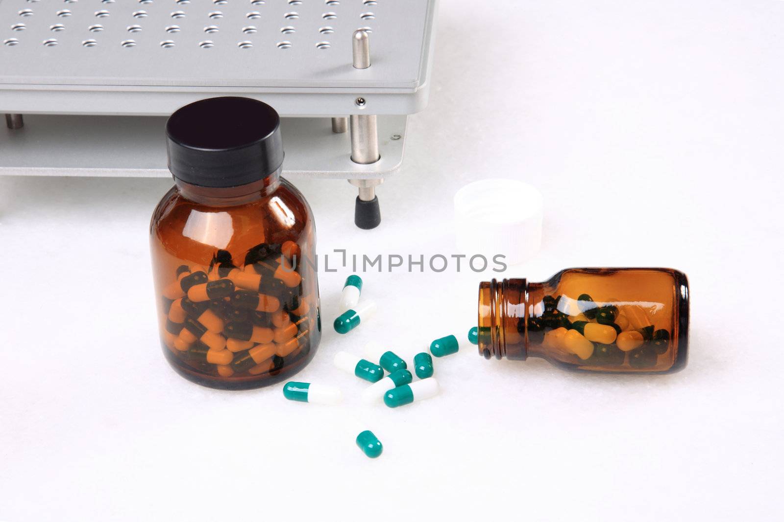 medicine pills pouring out of orange bottle on a white marble. selective focus