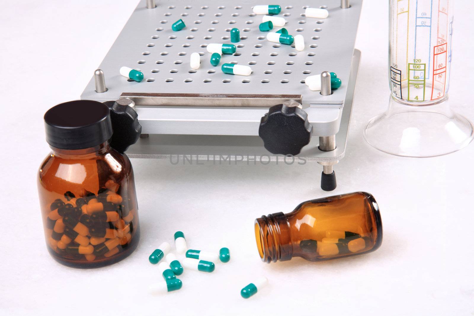 medicine pills pouring out of orange bottle on a white marble. selective focus