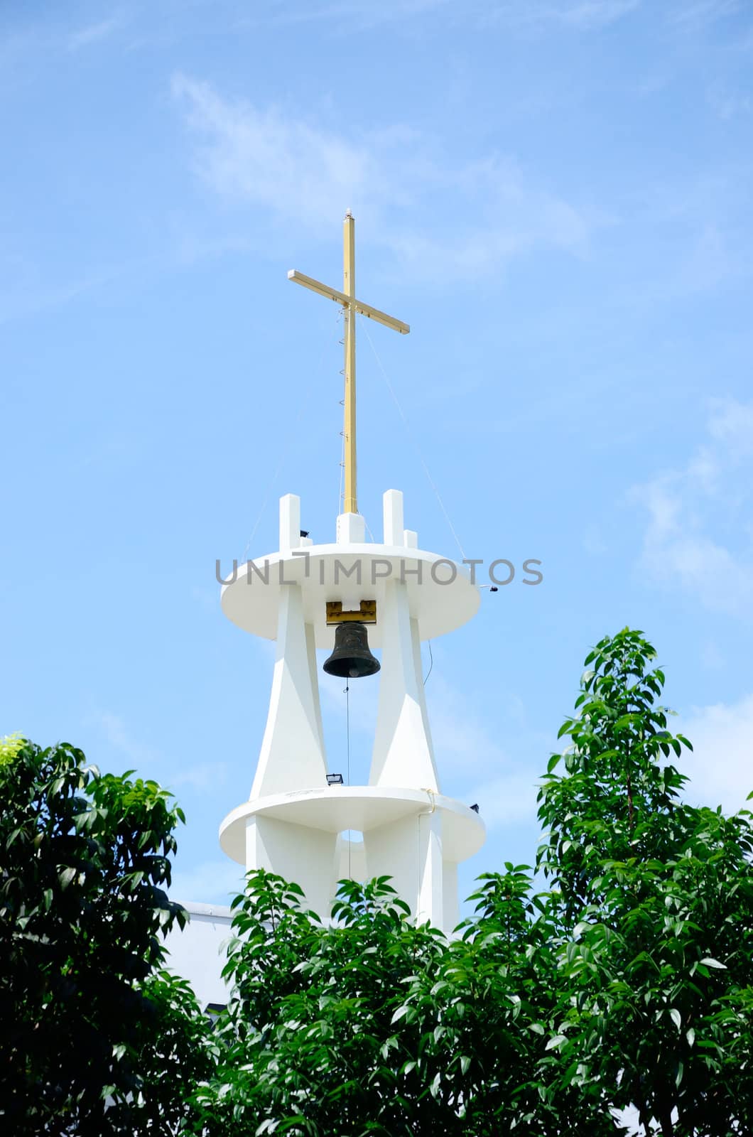 Cross on top of bell tower with sky background