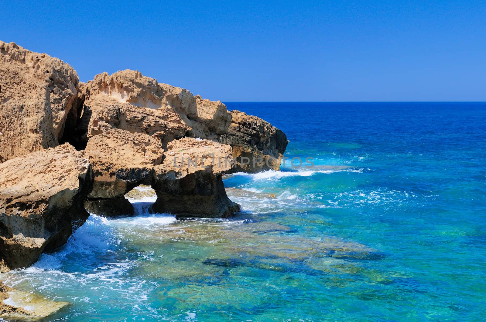 Rocky shore of the Mediterranean sea with clear water.