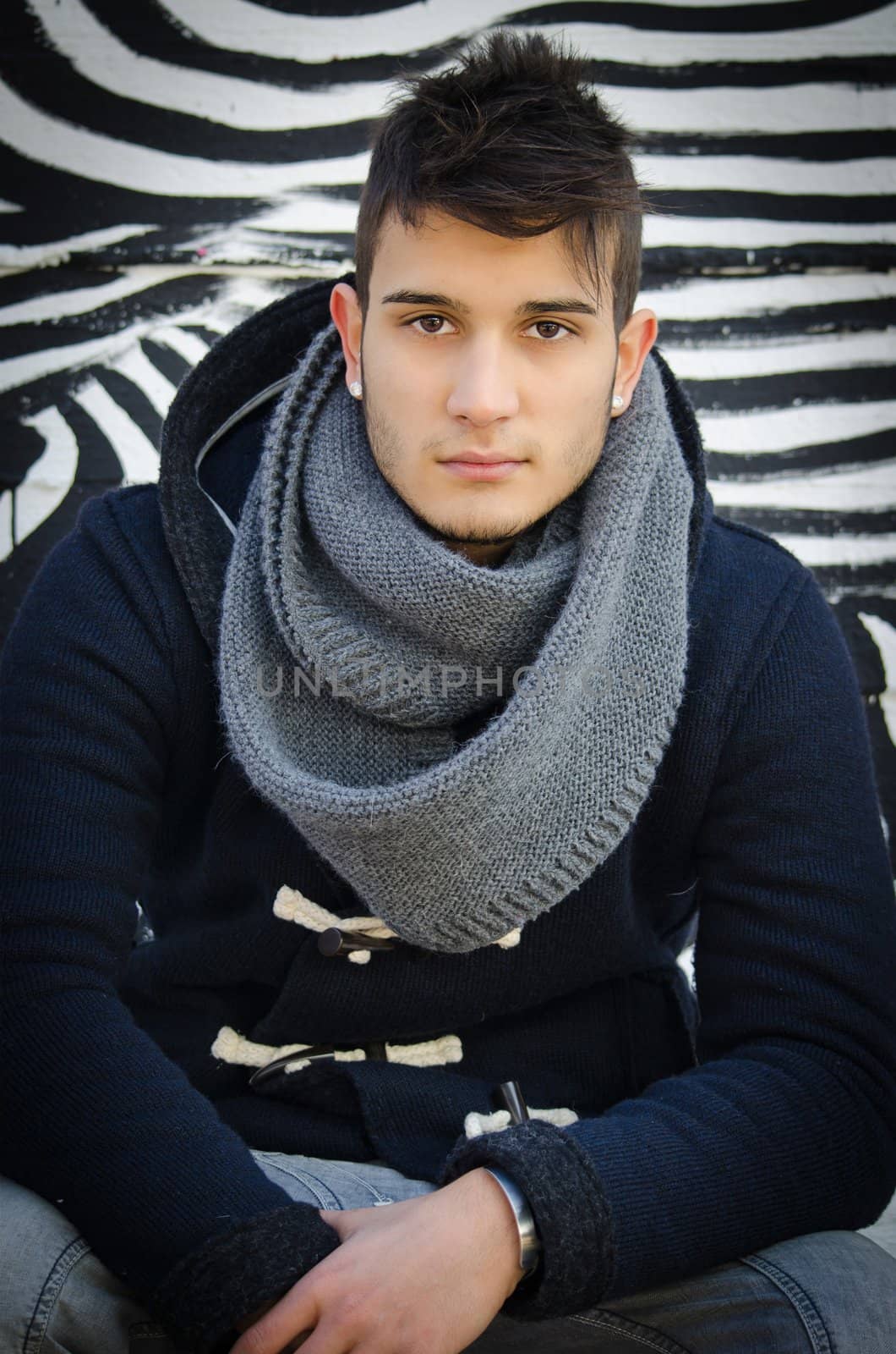 Handsome young man sitting against zebra striped design by artofphoto