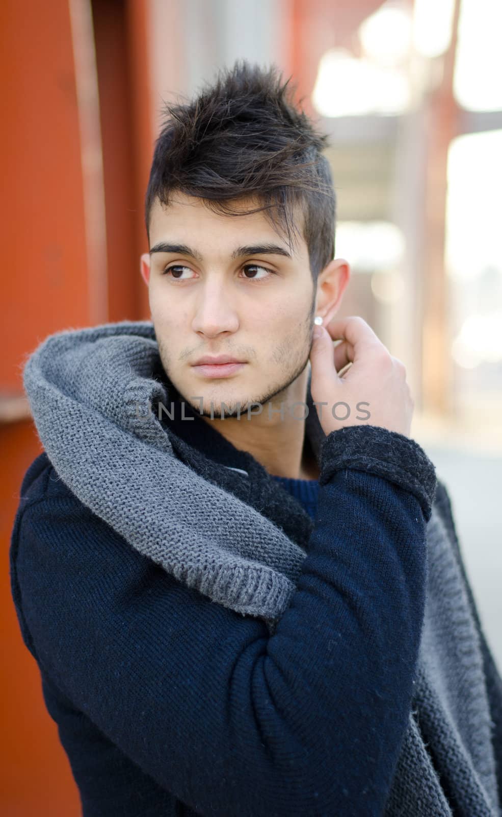 Handsome young man in urban or industrial environment, winter clothes