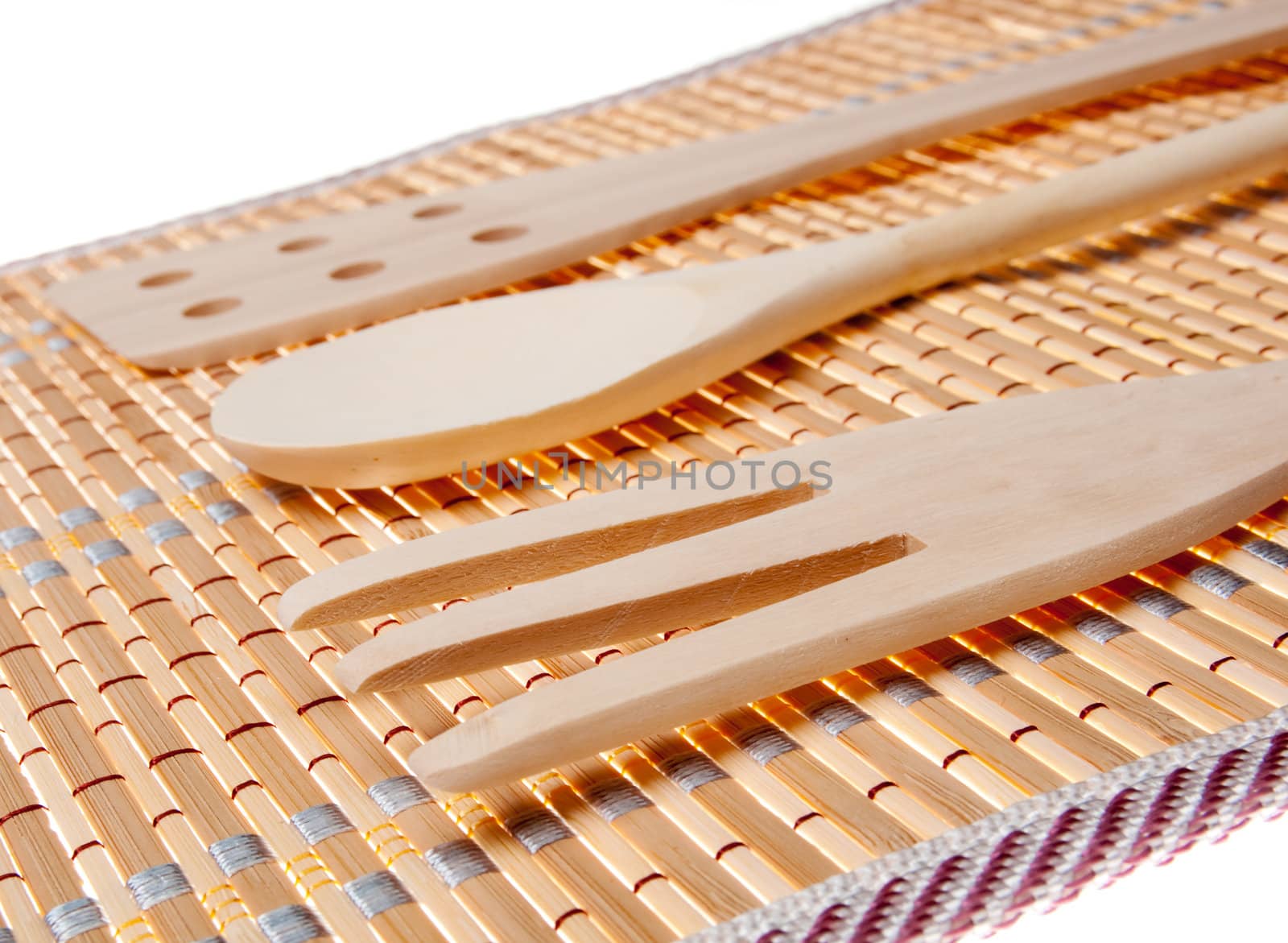 set of three wooden kitchenware on bamboo napkin