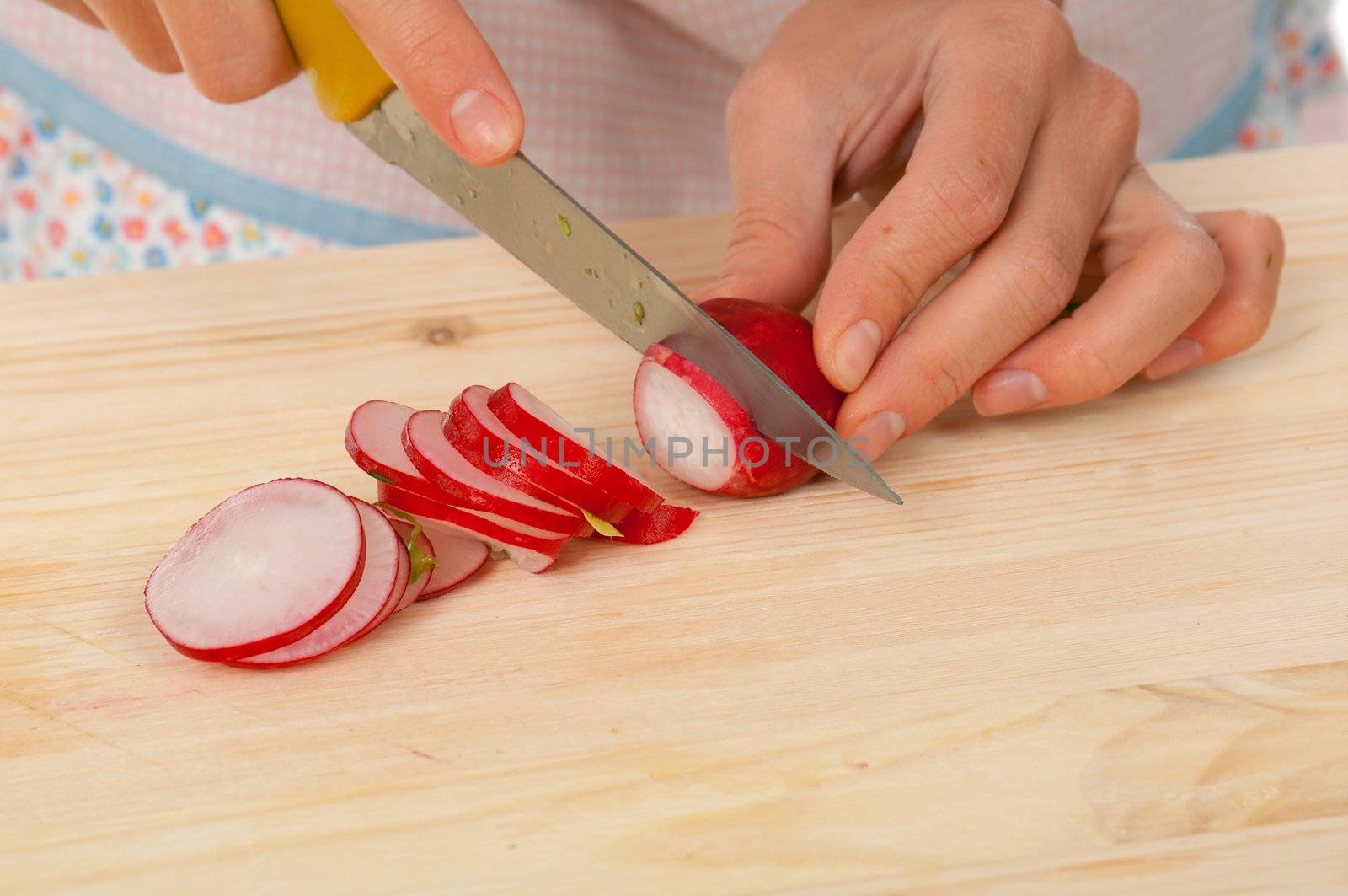 housewife preparing  small radish .Studio, white background. 