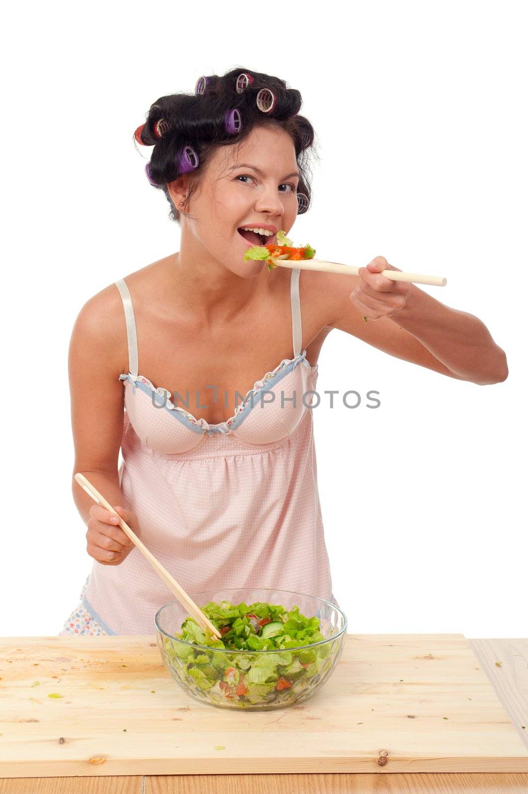 Pretty girl shuffle a salad .Studio, white background. 