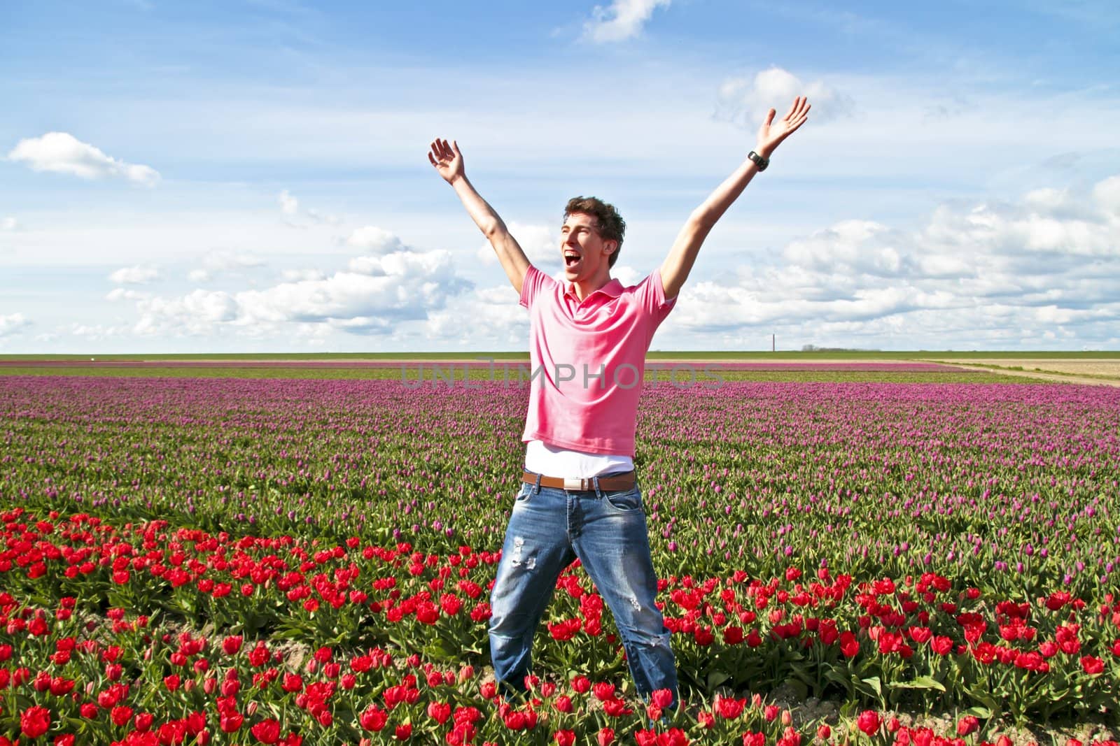 Happy guy in the tulip fields in the Netherlands