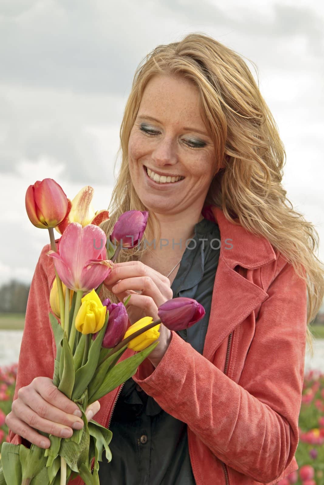 Beautiful woman with tulips in the tulip fields in the Netherlands