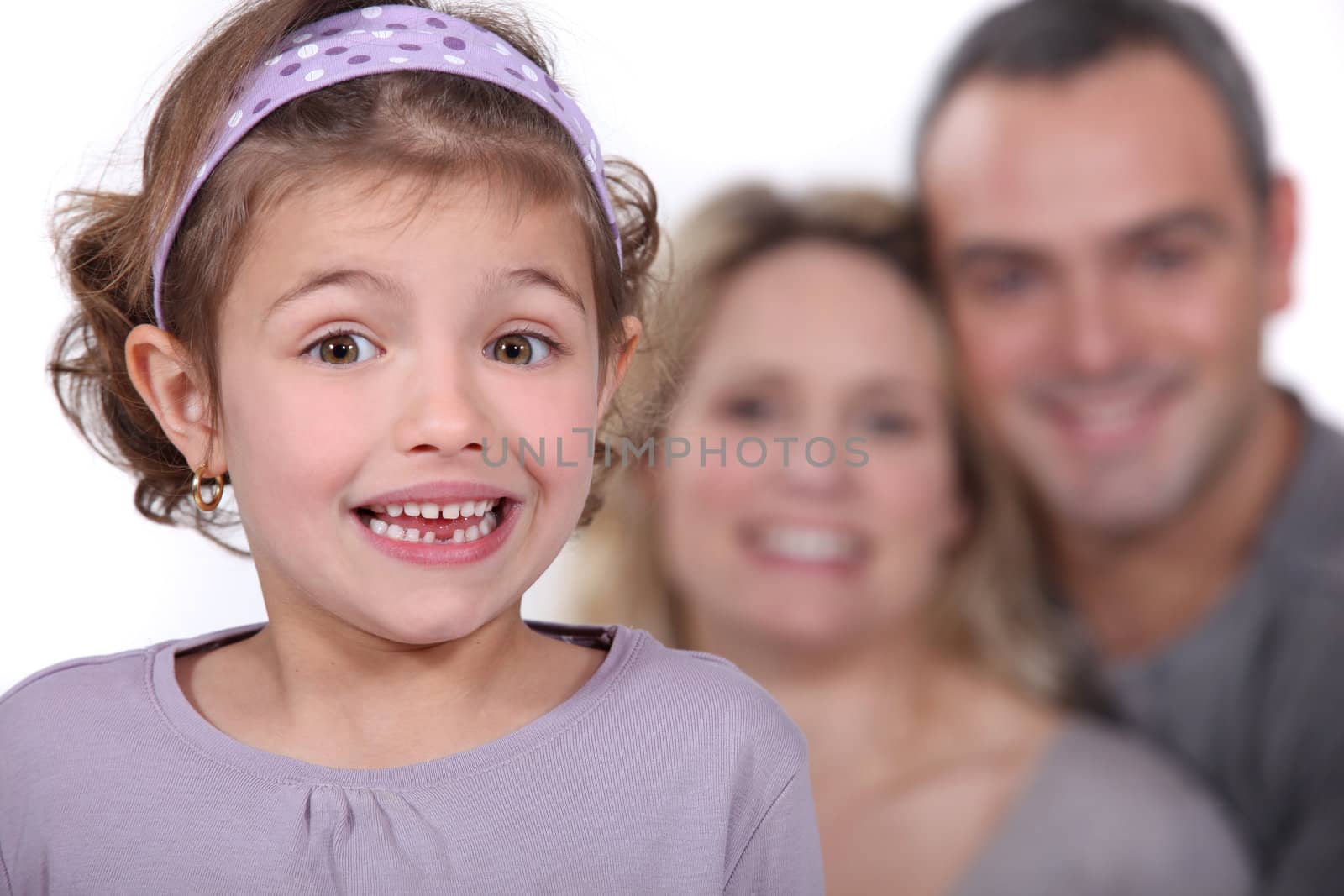 A cute little girl with her parents in the background. by phovoir