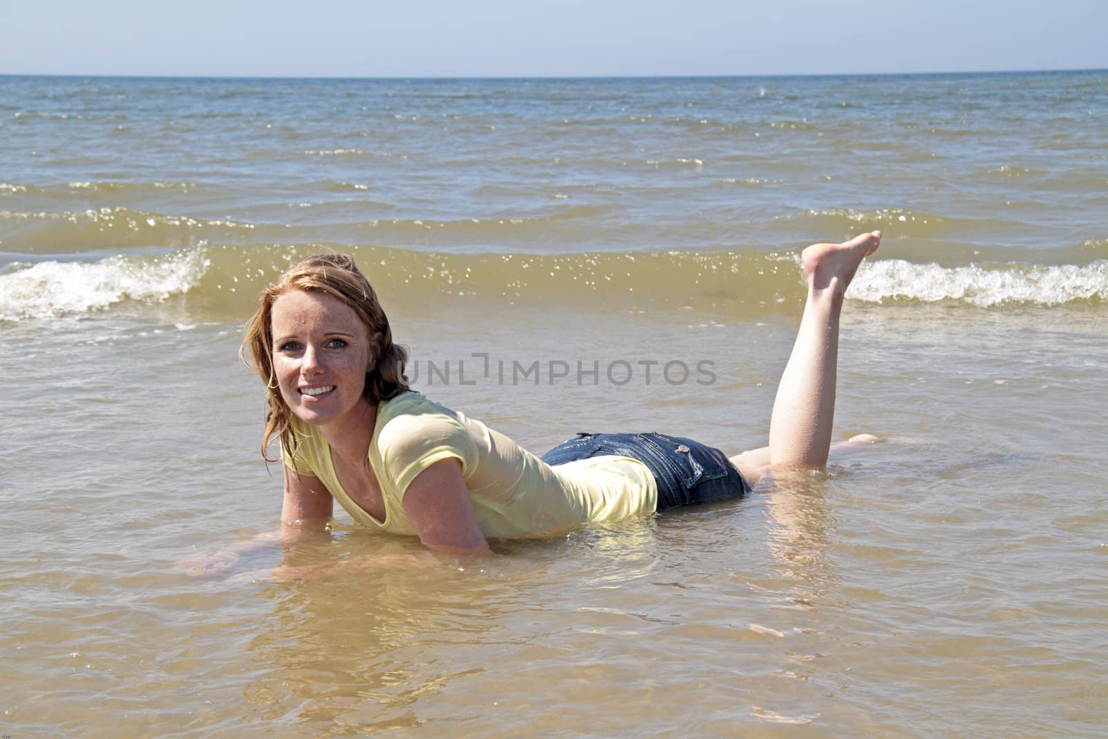 Happy woman lying in the water from the north sea