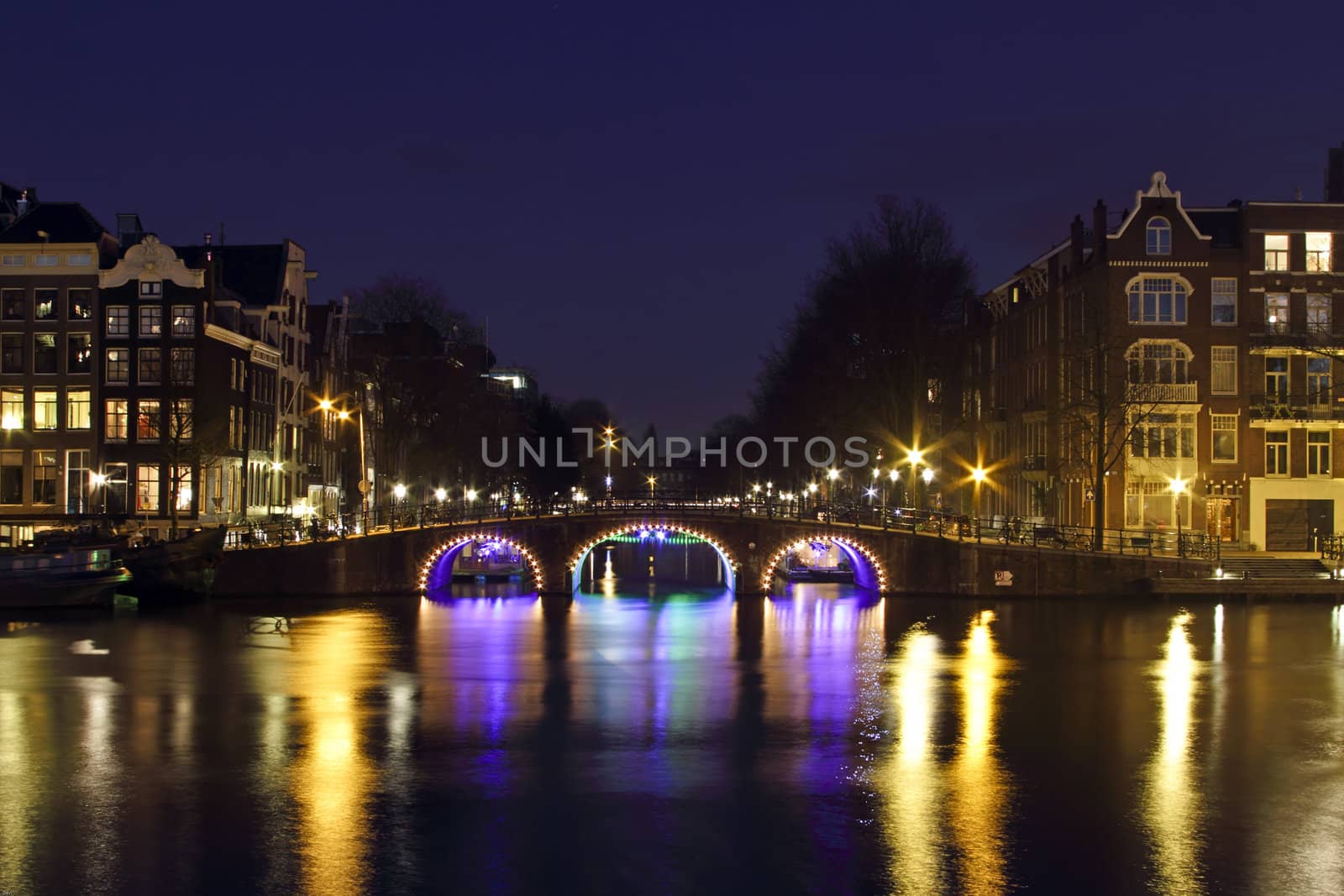 City scenic from Amsterdam by night at the river Amstel in the Nethrlands