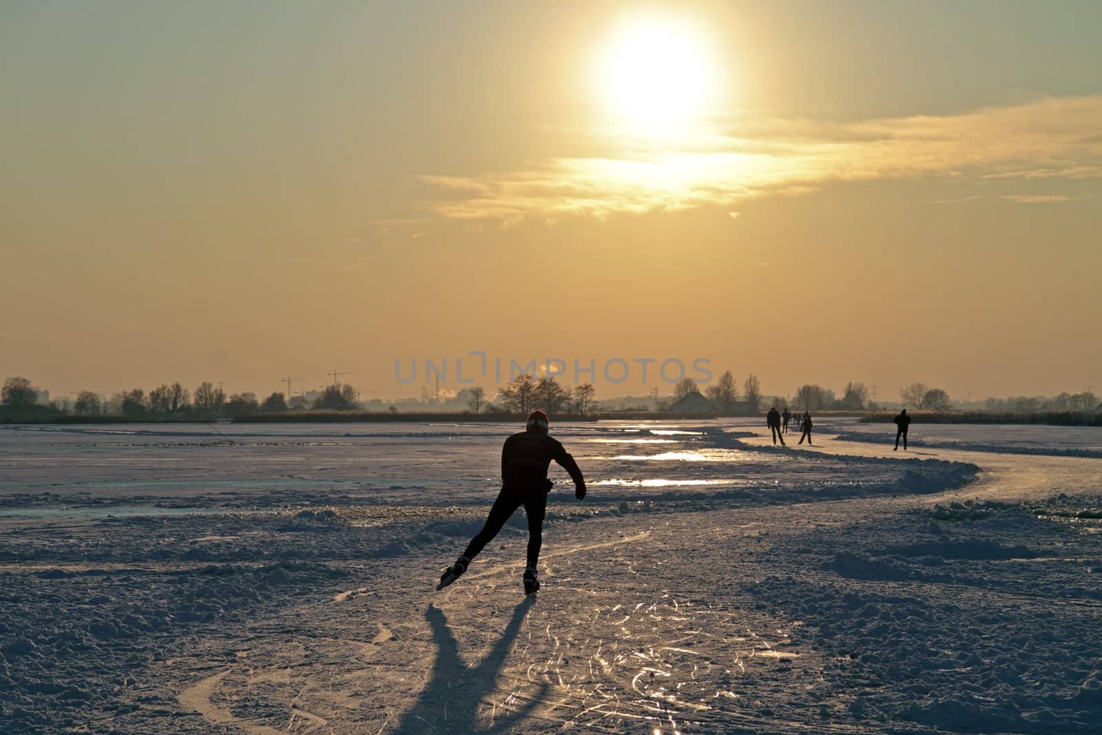 Ice skating in the countryside from the Netherlands at sunset