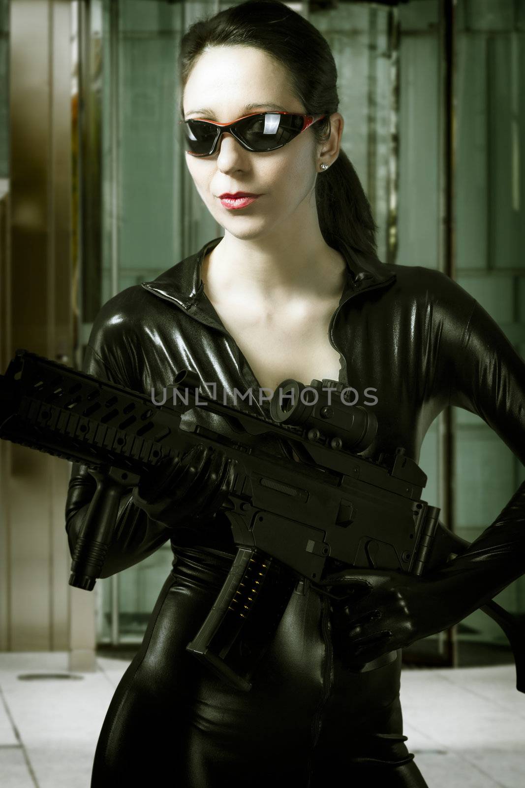 Caucasian beauty holding gun with business building in background