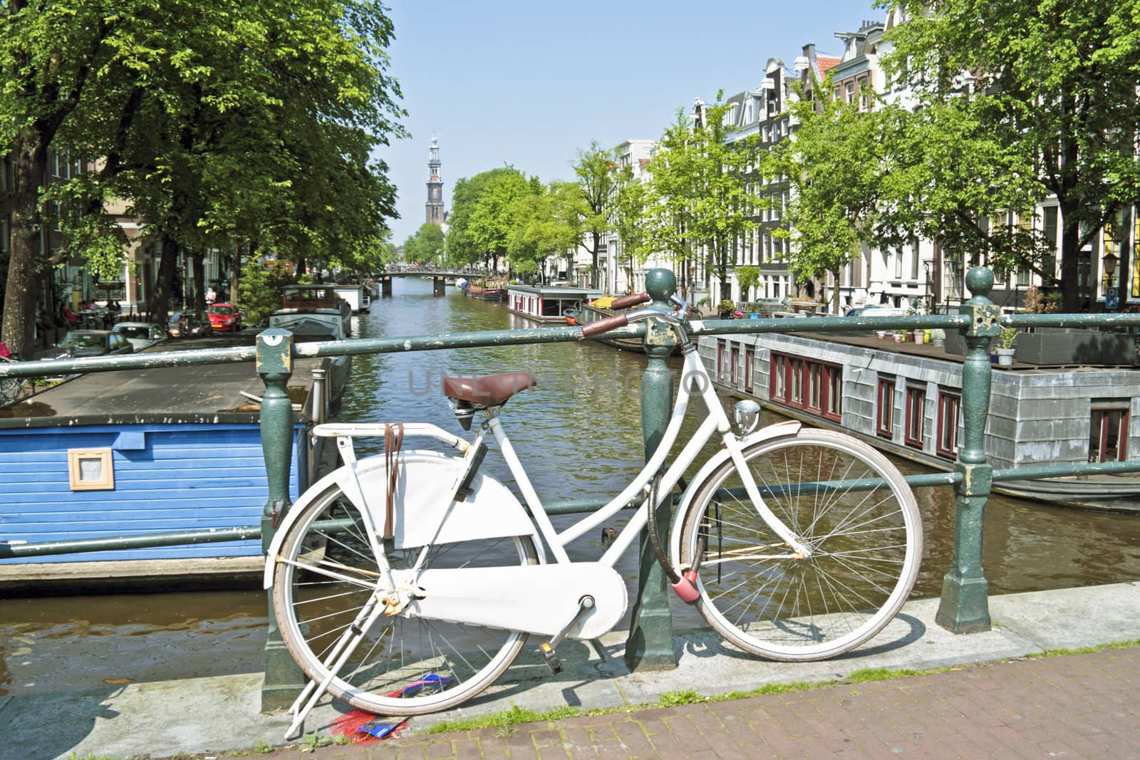 White bicycle in Amsterdam city center with the Westerkerk in the background in the Netherlands