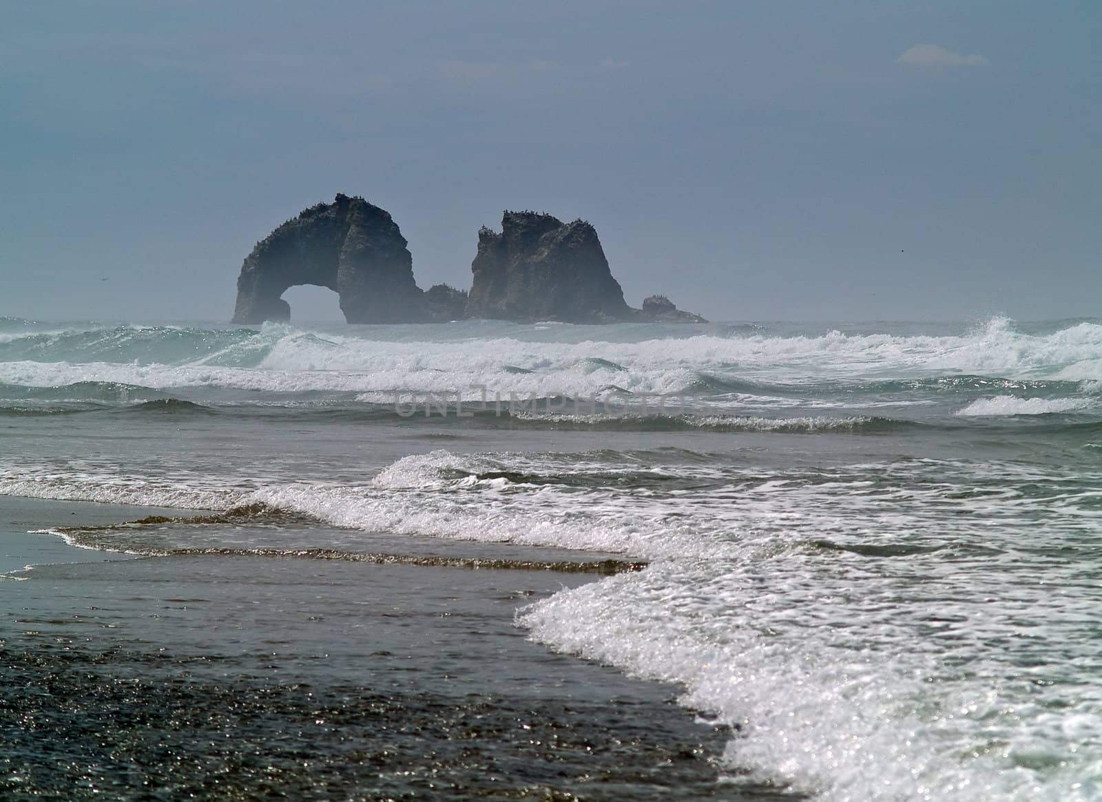 Arch Shaped Rock in the Ocean at the Beach by Frankljunior