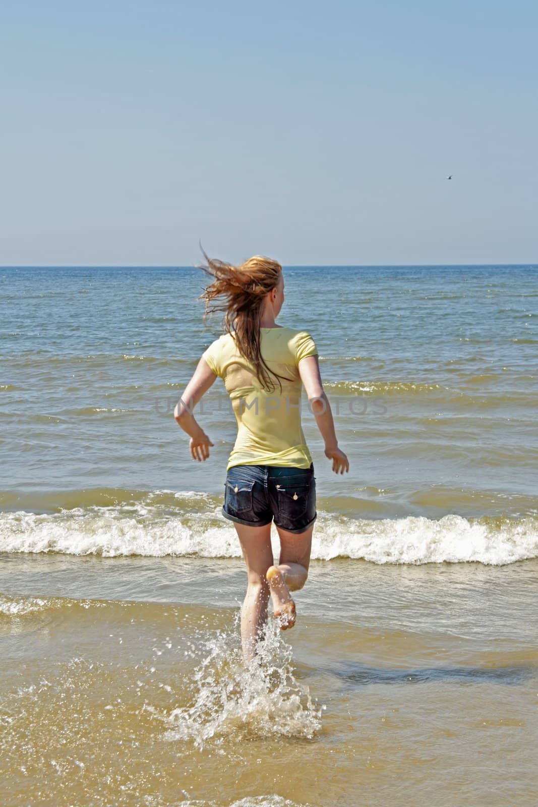 Young woman running in the water