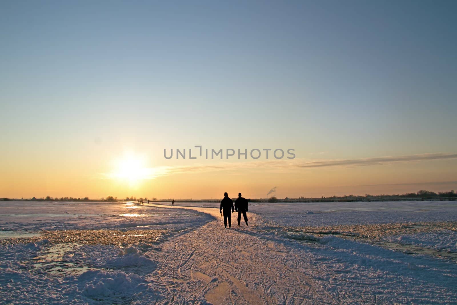 Ice skating in the countryside from the Netherlands at sunset