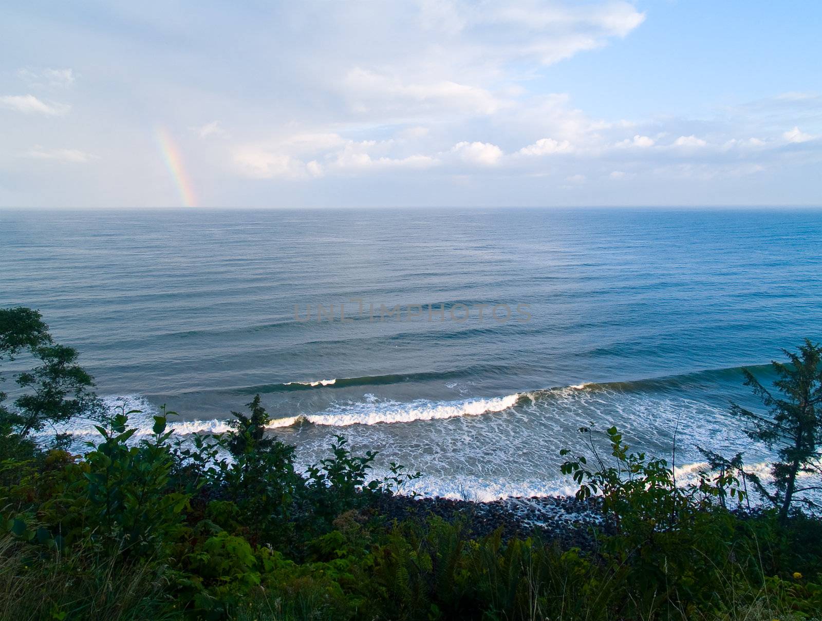 Rainbow Over the Ocean with a Partly Cloudy Sky