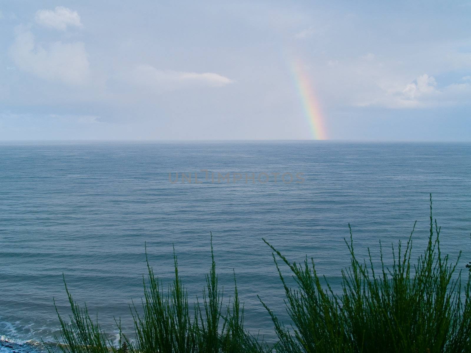 Rainbow Over the Ocean with a Partly Cloudy Sky