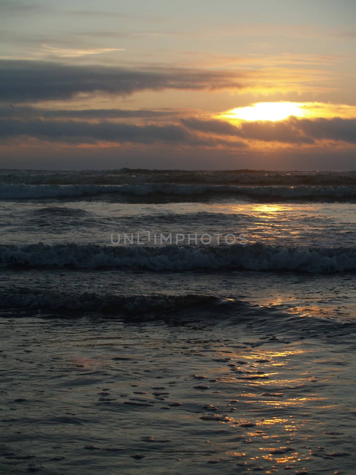 Beautiful Sunset Over the Ocean wth Waves in the Foreground